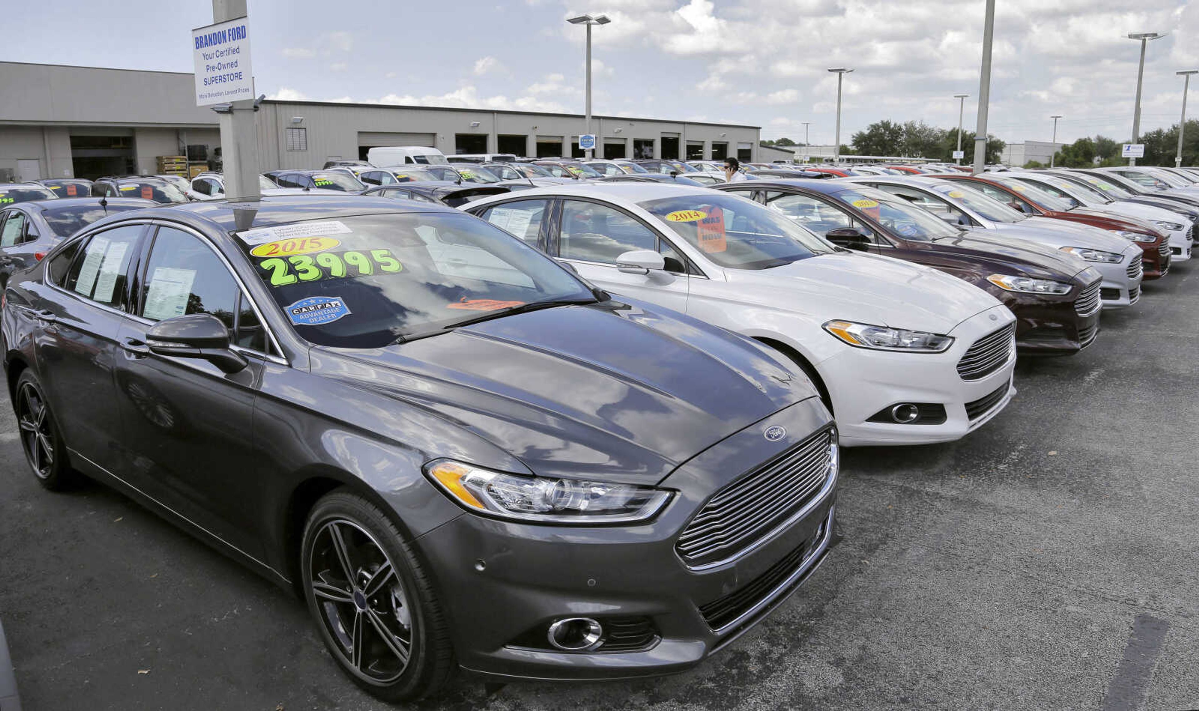 A car salesman works the telephone while searching through inventory at the certified used car lot Tuesday at Brandon Ford in Brandon, Florida. (Chris O'Meara ~ Associted Press)