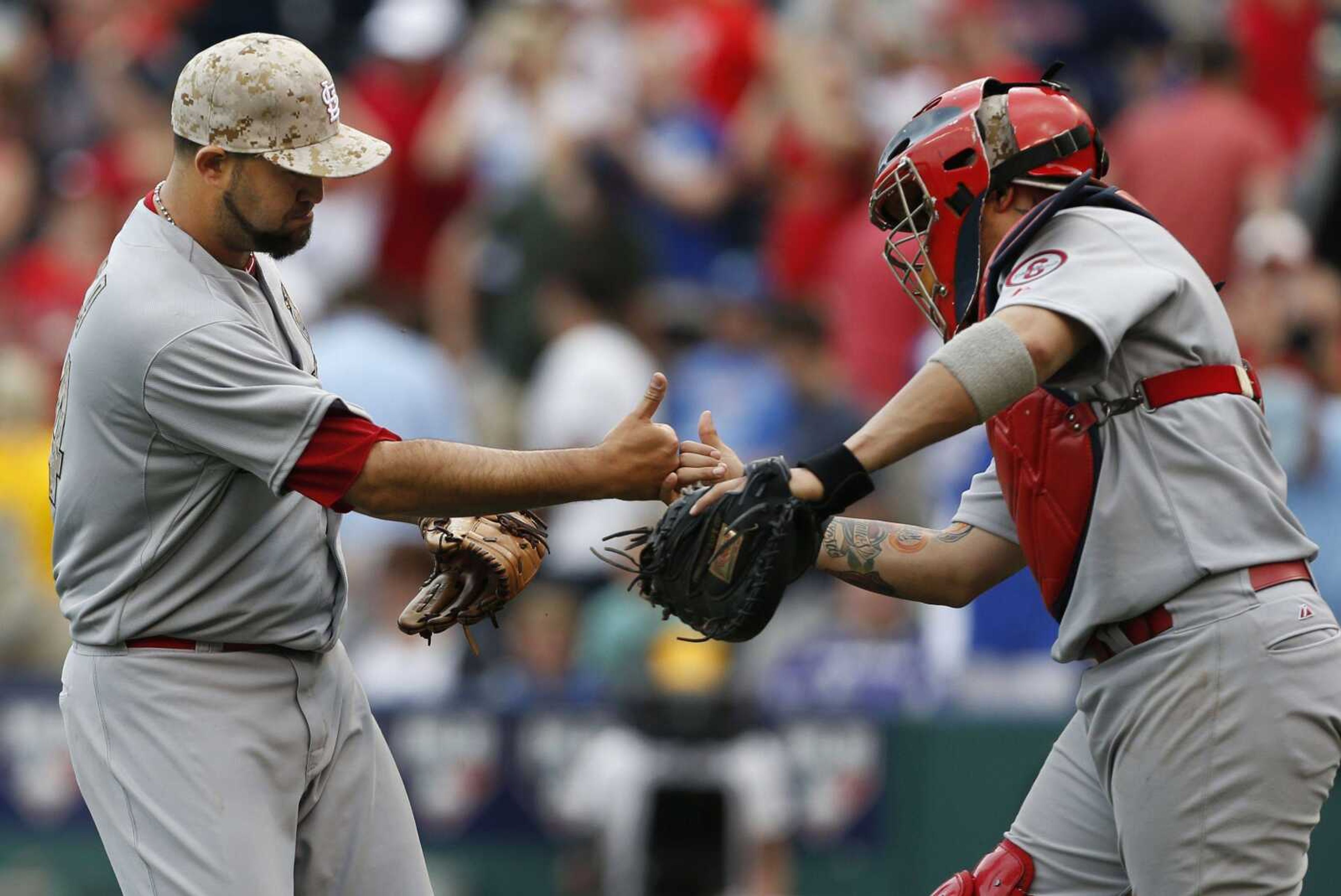 Cardinals closer Edward Mujica, left, and catcher Yadier Molina celebrate after Monday&#8217;s game. Mujica remained perfect in 15 save opportunities this season.