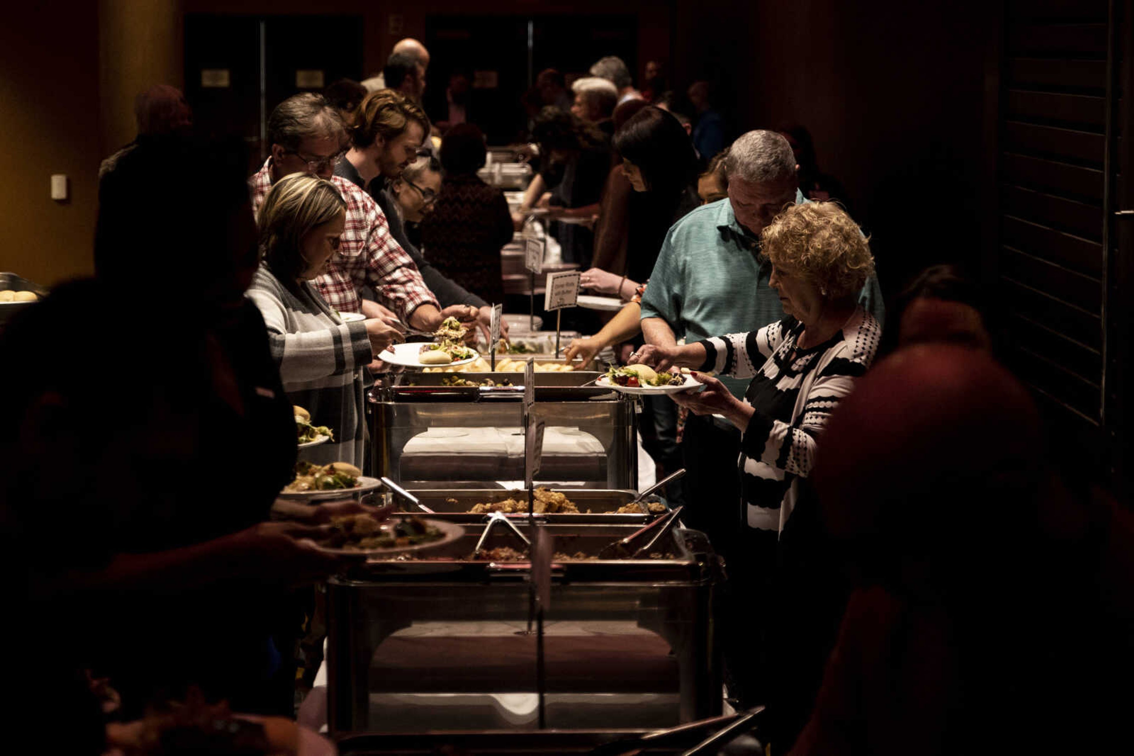 Community members get their food from the buffet during the Old Town Cape 20th anniversary dinner celebration at the Isle Casino Thursday, Feb. 28, 2019, in Cape Girardeau.