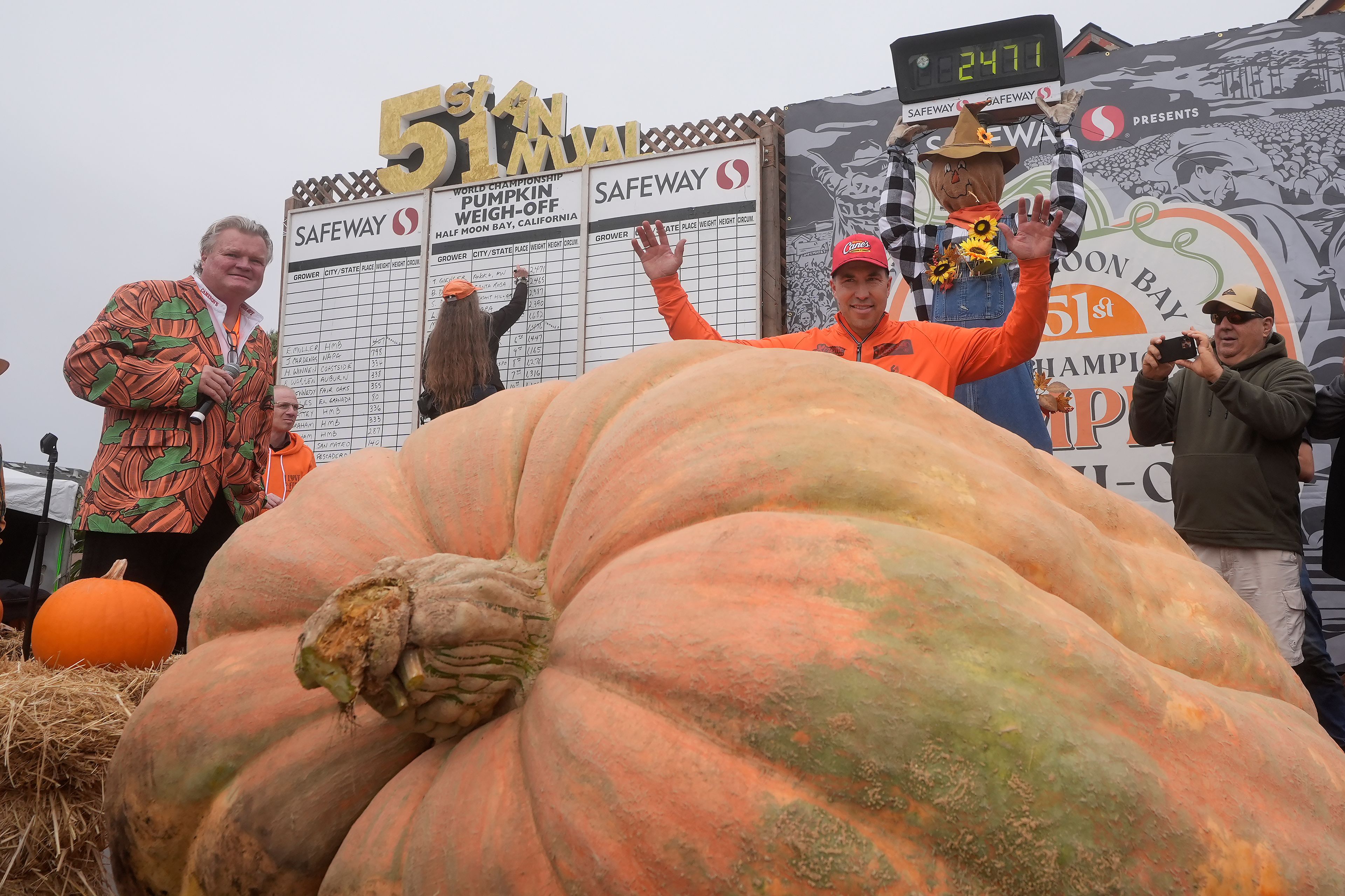 Travis Gienger, of Anoka, Minn., middle, celebrates after his pumpkin weighed in at 2,471 pounds to win at the Safeway World Championship Pumpkin Weigh-Off in Half Moon Bay, Calif., Monday, Oct. 14, 2024. (AP Photo/Jeff Chiu)