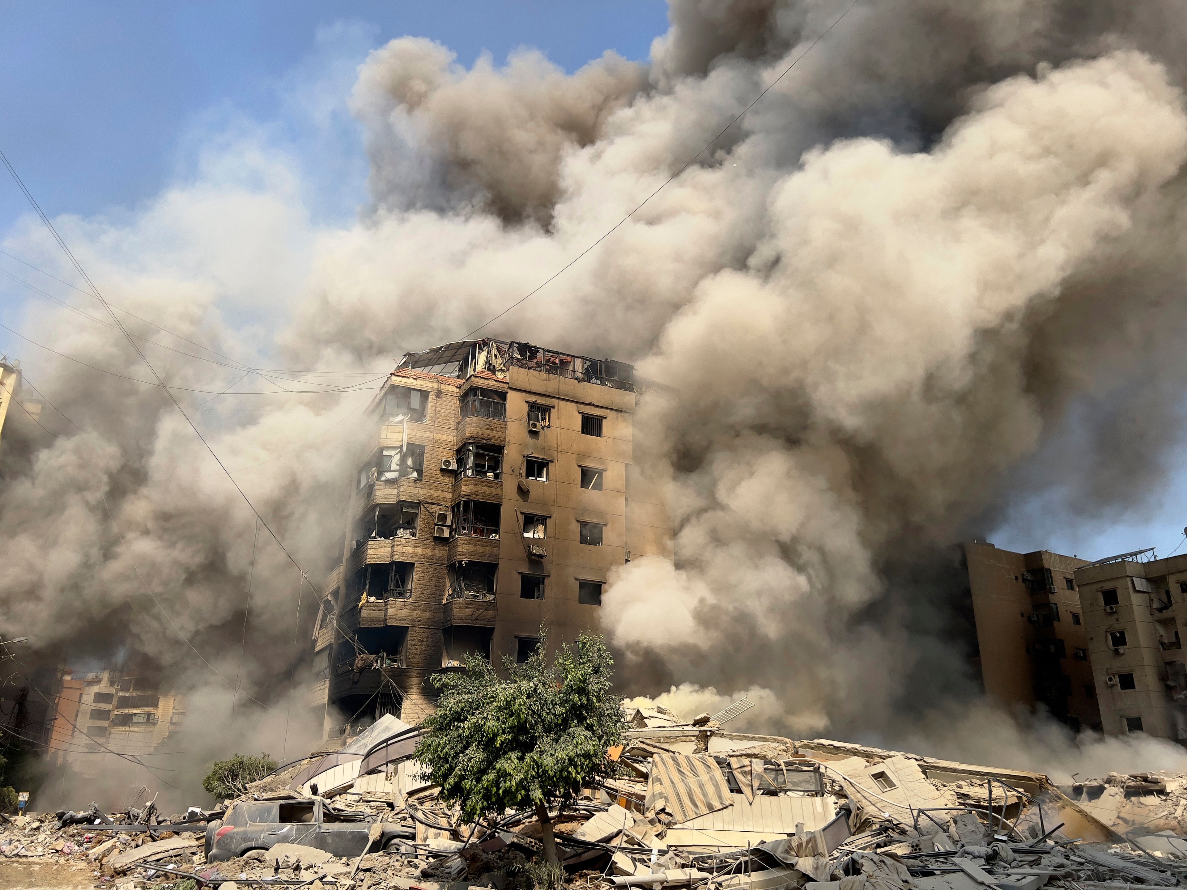 FILE - Smoke rises as a building collapses in Beirut's southern suburbs in Lebanon, Saturday, Sept. 28, 2024. (AP Photo/Hussein Malla, File)