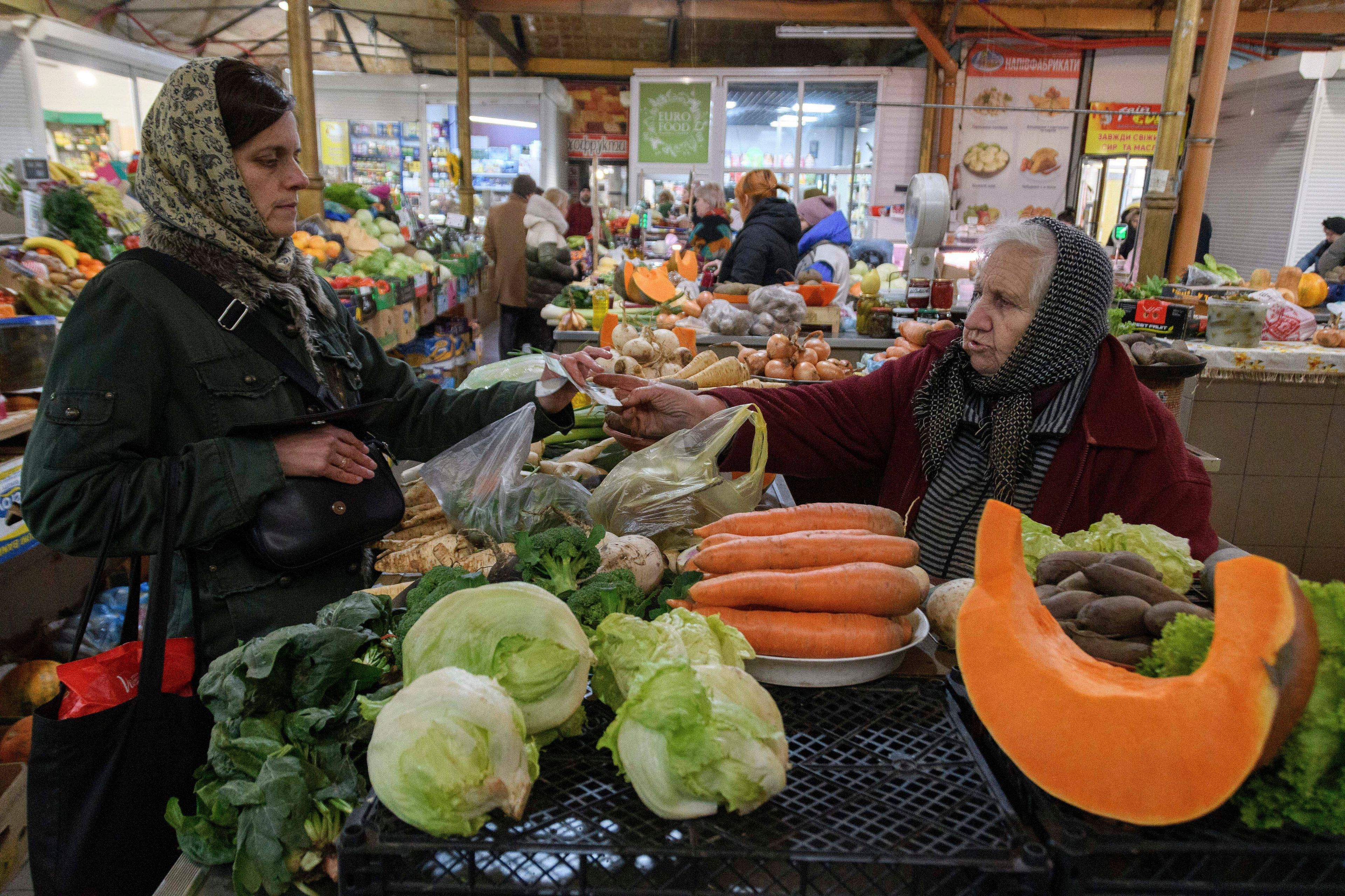 A woman buys vegetables in a market in Lviv, Ukraine, Monday Nov. 11, 2024. (AP Photo/Mykola Tys)