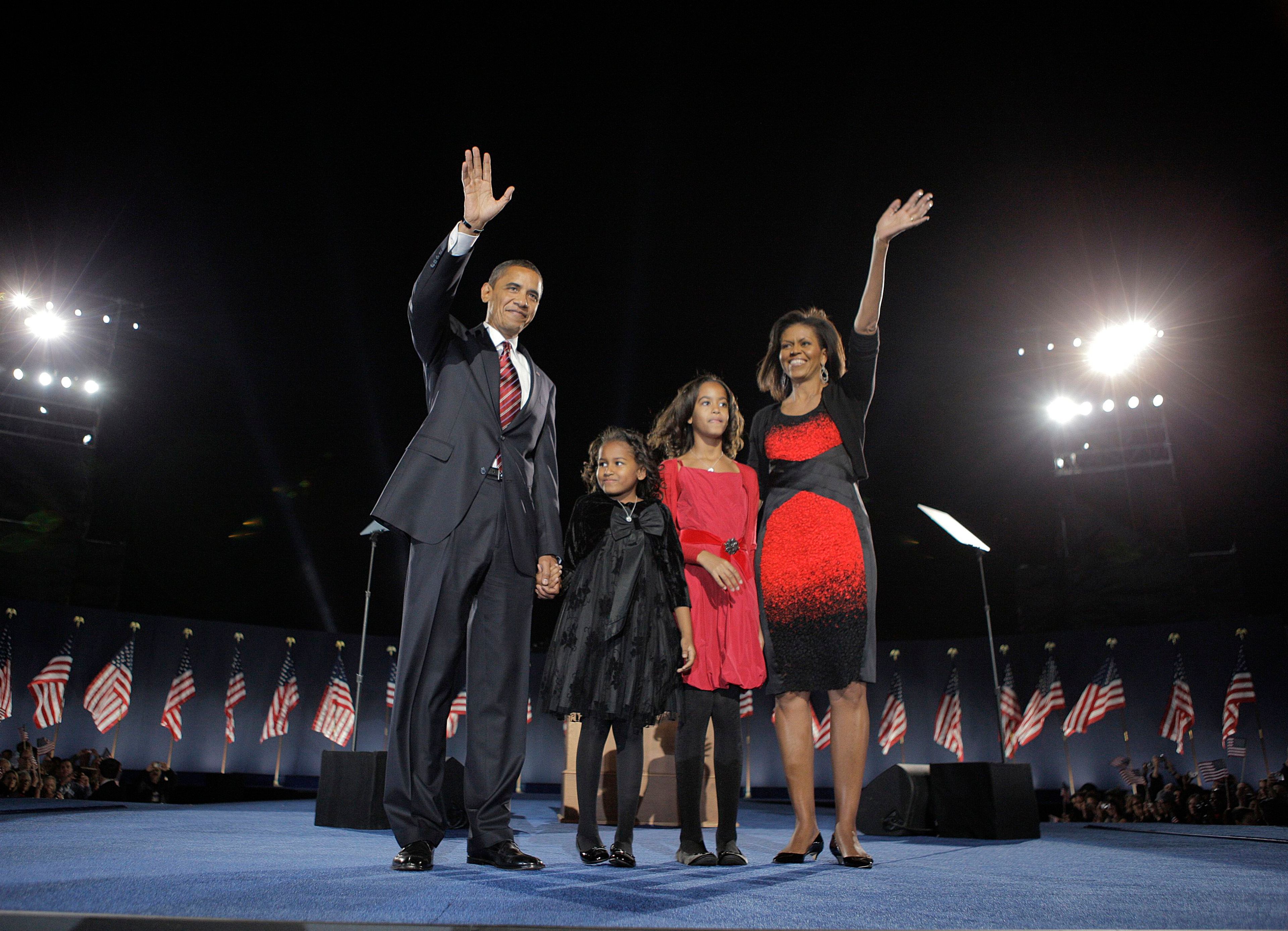 In this Nov. 4, 2008 file photo, President-elect Barack Obama, left, his wife Michelle Obama, right, and two daughters, Sasha, 7, and Malia, 10, second from right, wave at the election night rally in Chicago. 