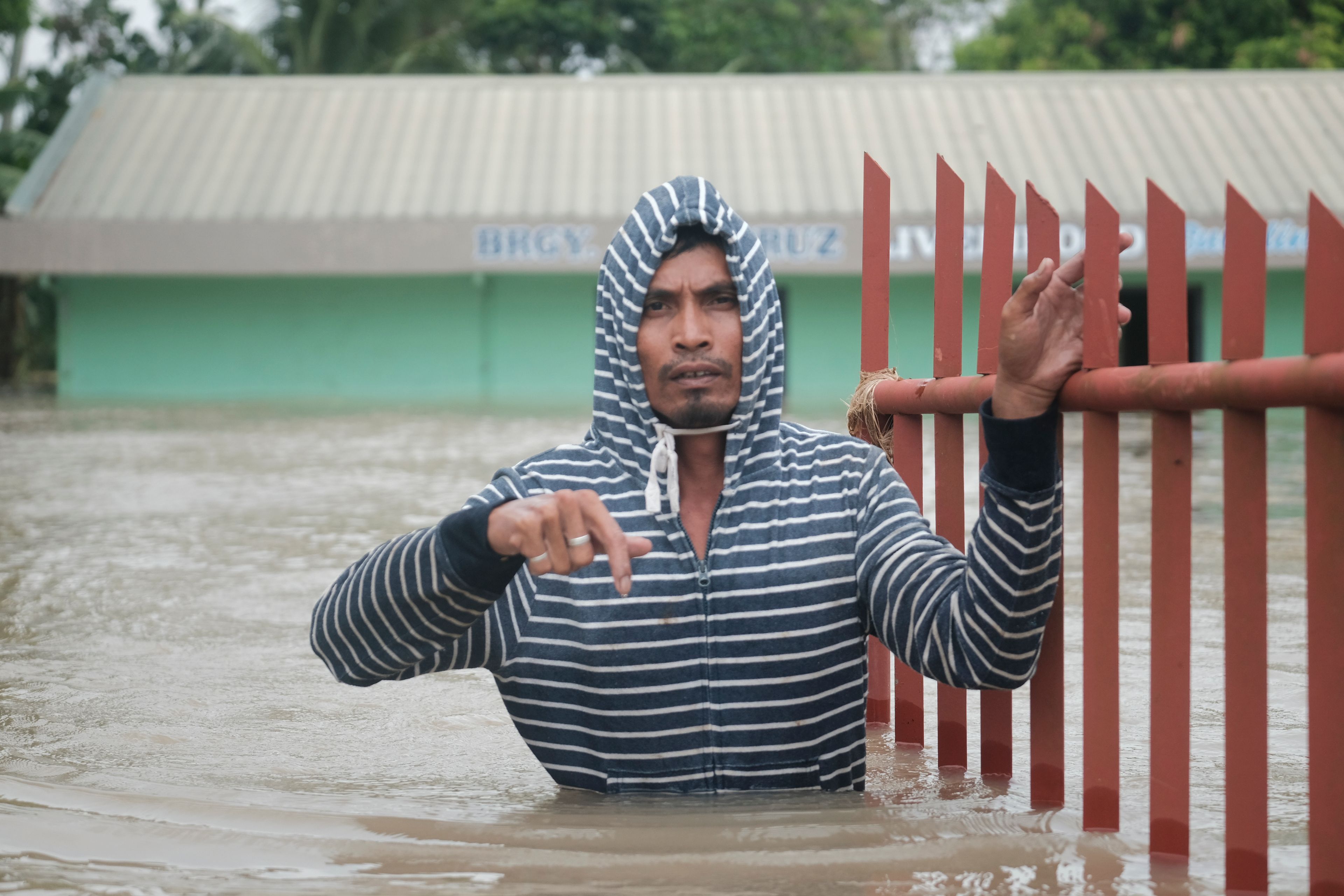 A resident walks along floods caused by Tropical Storm Trami, locally named Kristine, as it continues to inundate Libon town, Albay province, Philippines on Thursday Oct. 24, 2024. (AP Photo/John Michael Magdasoc)