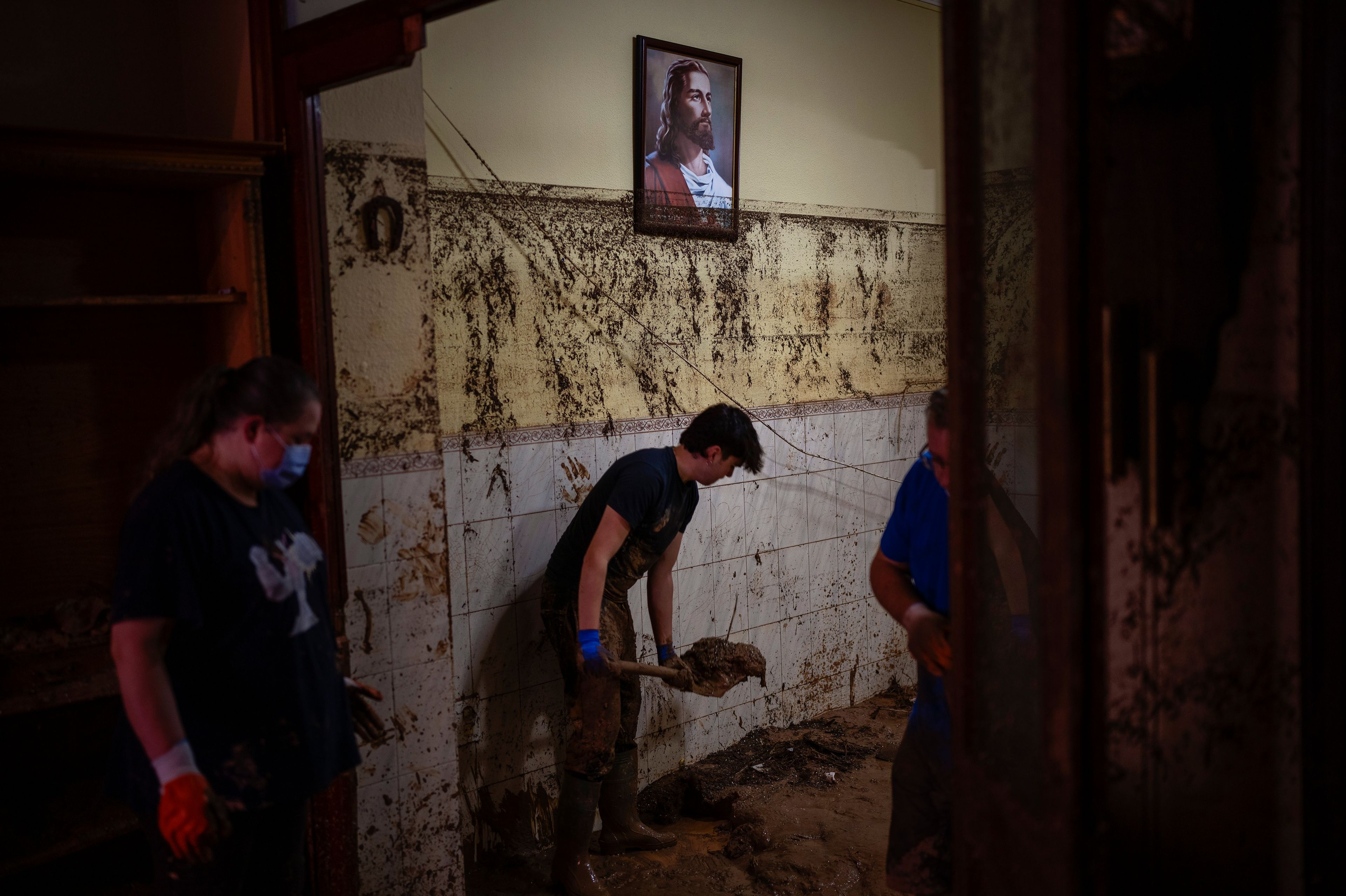 A painting hangs near the water level marker as resident remove the mud in a house after floods in Paiporta, Valencia, Spain, Tuesday, Nov. 5, 2024. (AP Photo/Emilio Morenatti)