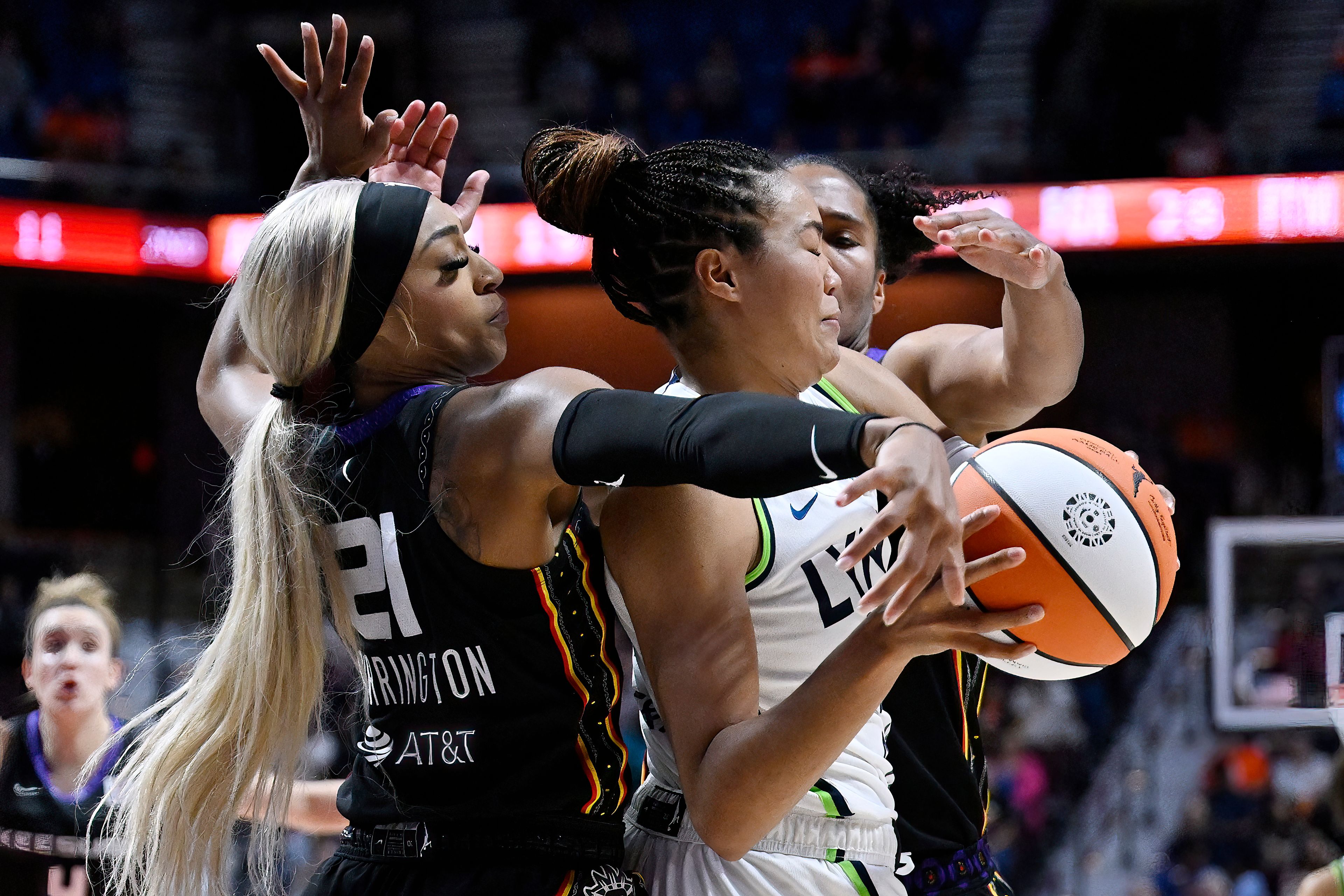 Connecticut Sun guard DiJonai Carrington, left, and Connecticut Sun forward Alyssa Thomas, right, pressure Minnesota Lynx forward Napheesa Collier during the first half of Game 4 in the WNBA basketball semifinals, Sunday, Oct. 6, 2024, in Uncasville, Conn. (AP Photo/Jessica Hill)