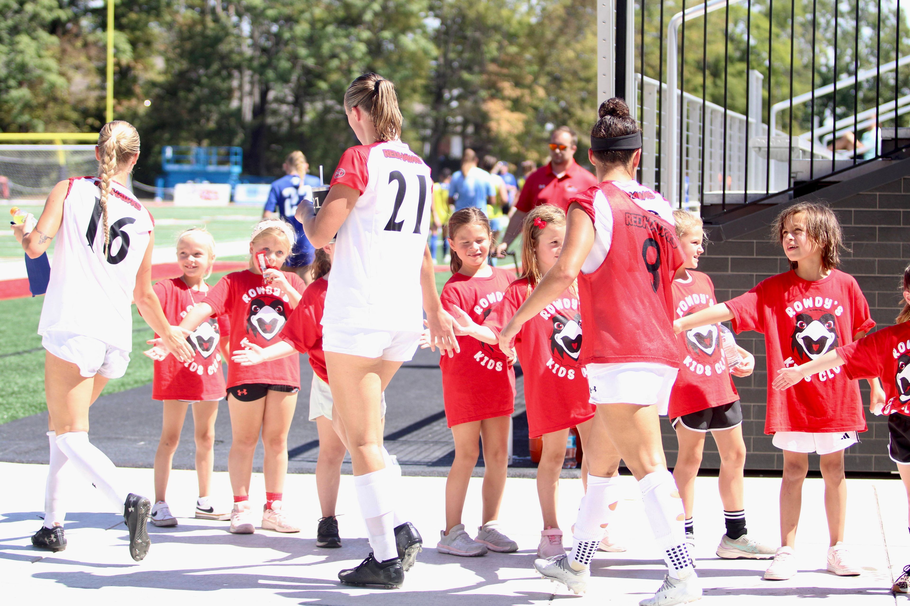 SEMO's Alayna Jakul (16), Elizabeth Rater (21) and Emily Baker high five members of Rowdy's Kids Klub before the second half of the Sept. 1 game between the Redhawks and Indiana State.
