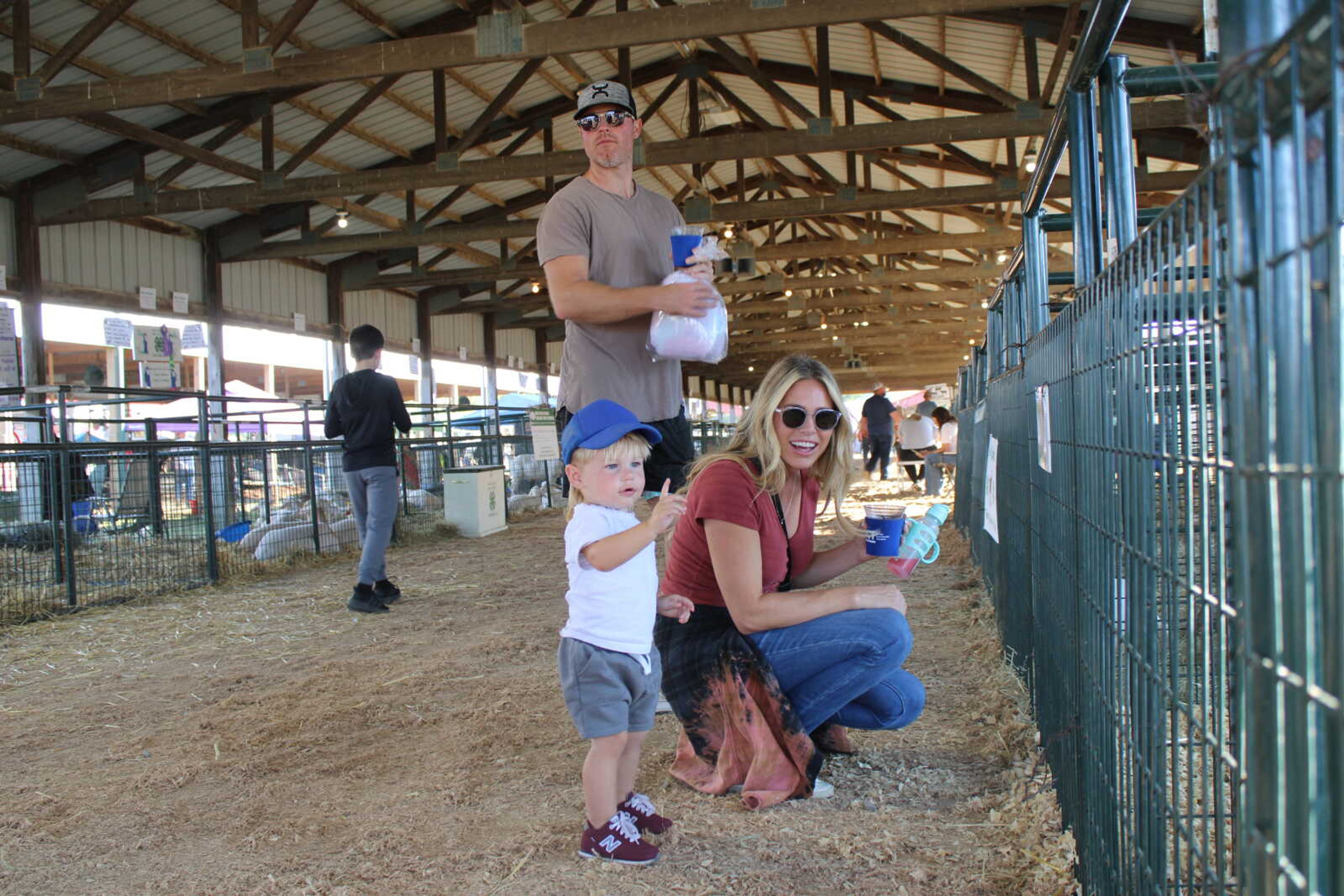 Slyer Simmons and his mother Kaitlin Simmons look at goats.