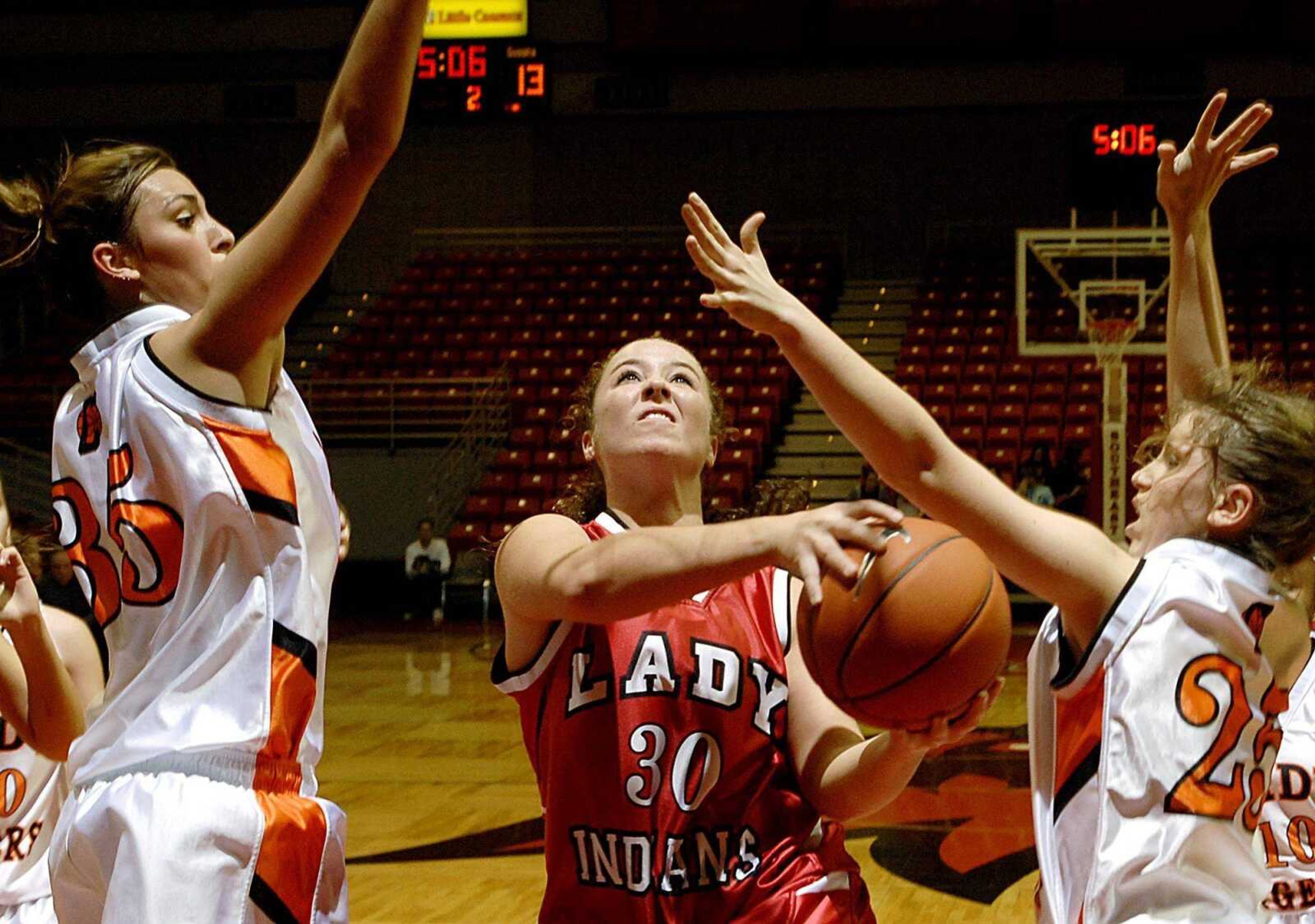 Jackson's Kelci Keit split Central's Wendi Zickfield, left, and Lauren Kinsey on a drive to  the basket during the second quarter of the third-place game in the Saint Francis Medical Center Holiday Classic at the Show Me Center. (Aaron Eisenhauer)