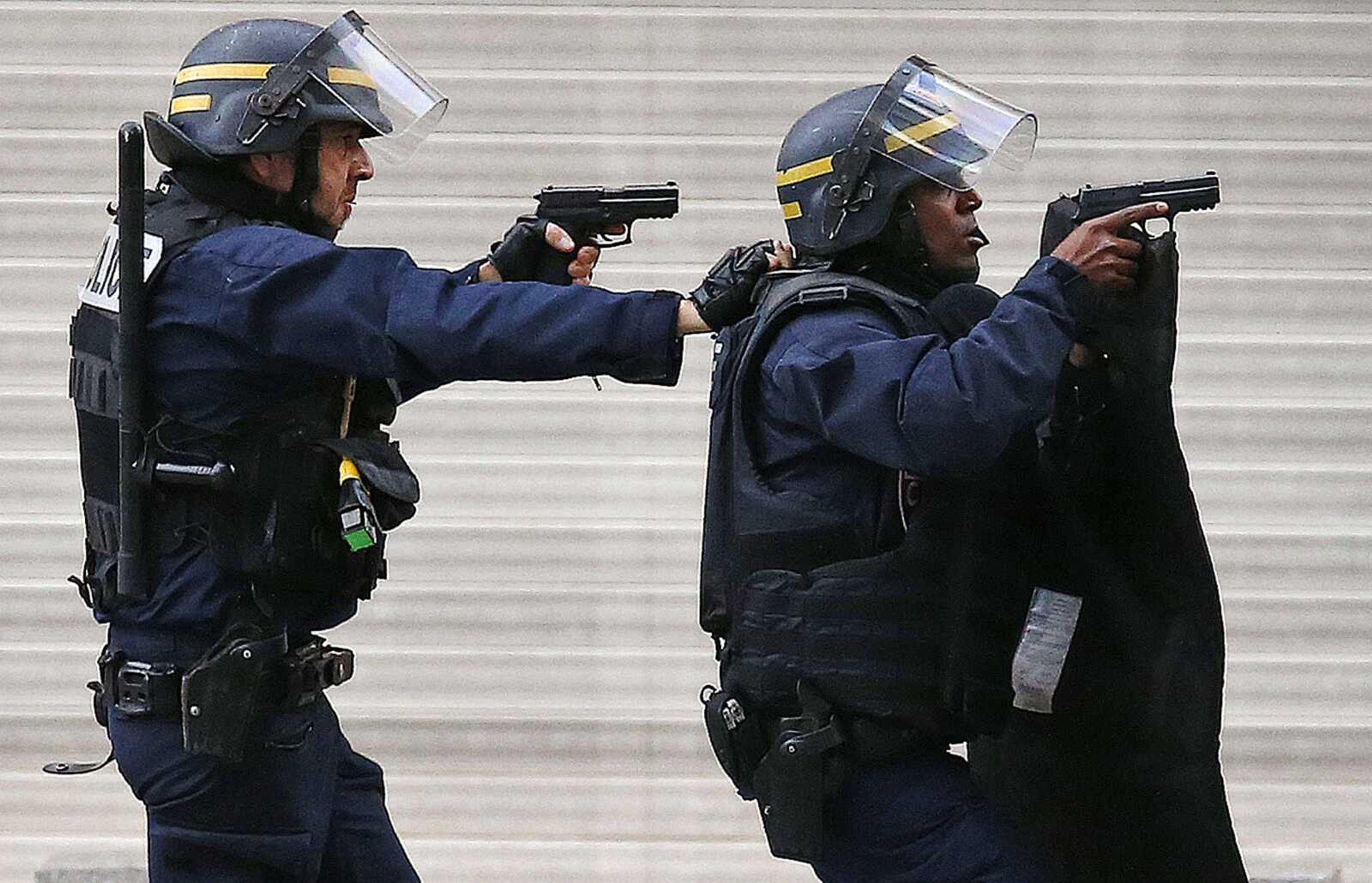 Police forces operate during a raid at an apartment Wednesday in Saint-Denis, a northern suburb of Paris. (Francois Mori ~ Associated Press)