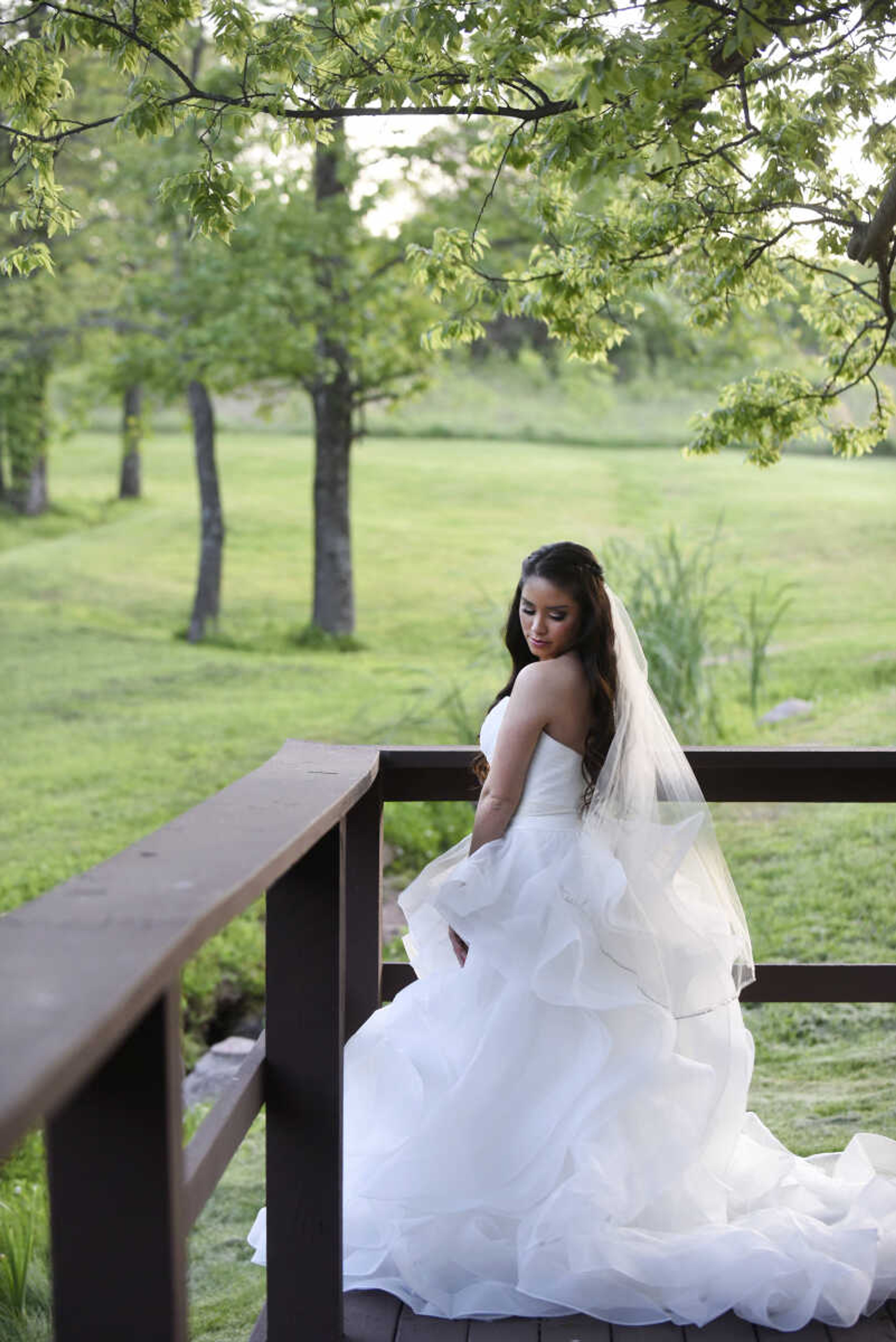 Allure Bridals strapless horsehair gown with flower belt from Enzoani, veil from Giselle Bridal and Jim Ball earrings. Available at Joy's Bridal in Sikeston, Missouri.