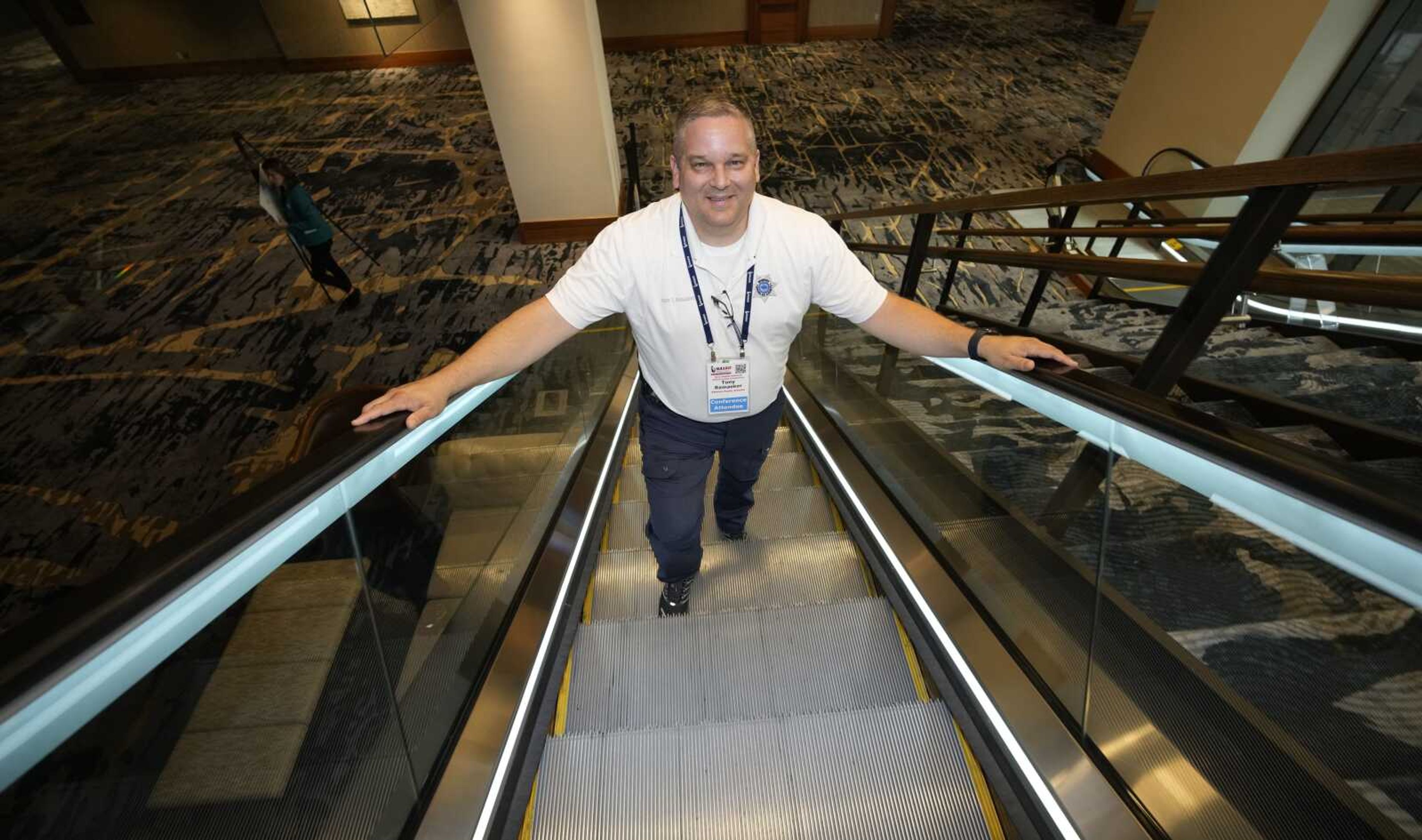 Student resource officer Tony Ramaeker, from Elkhorn, Nebraska, heads up an escalator while attending a convention July 5 in Denver.