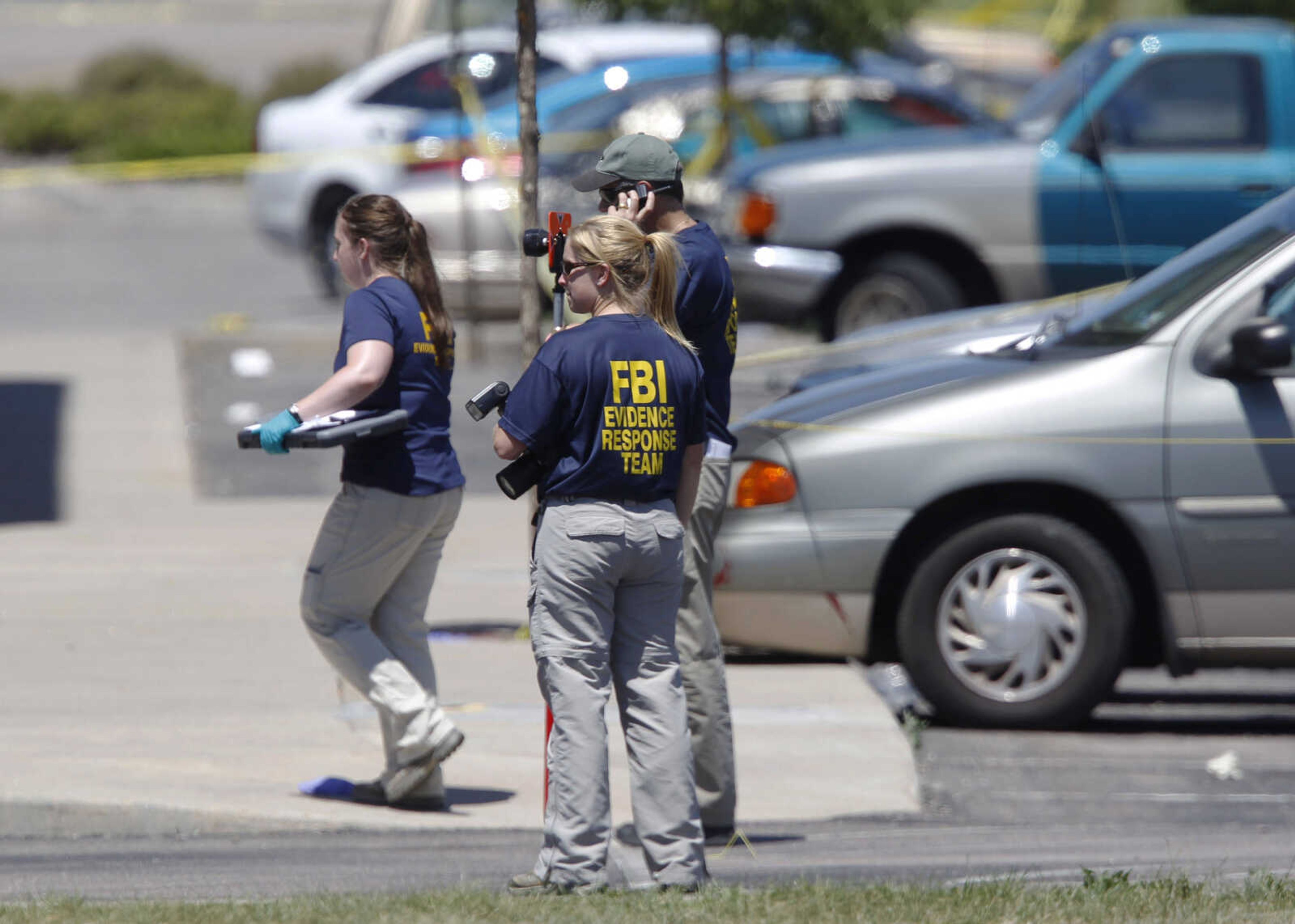 Investigators continue to look over evidence behind the Century 16 theatre east of the Aurora Mall in Aurora, Colo., on Friday, July 20, 2012. Authorities report that 12 died and more than three dozen people were shot during an assault at the theatre during a midnight premiere of "The Dark Knight." (AP Photo/David Zalubowski)