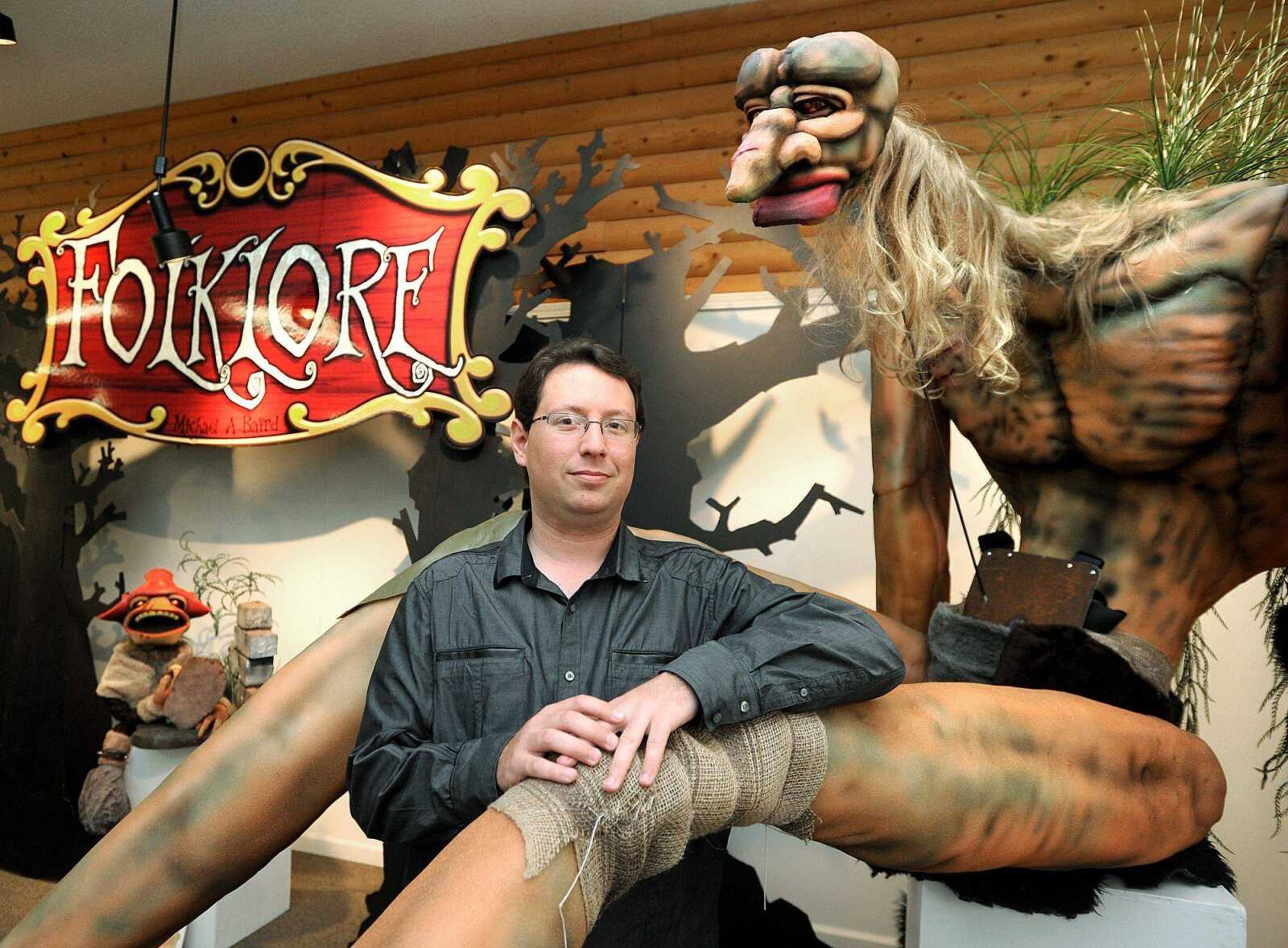 Michael A. Baird poses with Tiny, a folklore giant, at the Arts Council of Southeast Missouri. Baird&#8217;s show, &#8220;Folklore,&#8221; features puppets found in such tales. (Laura Simon)