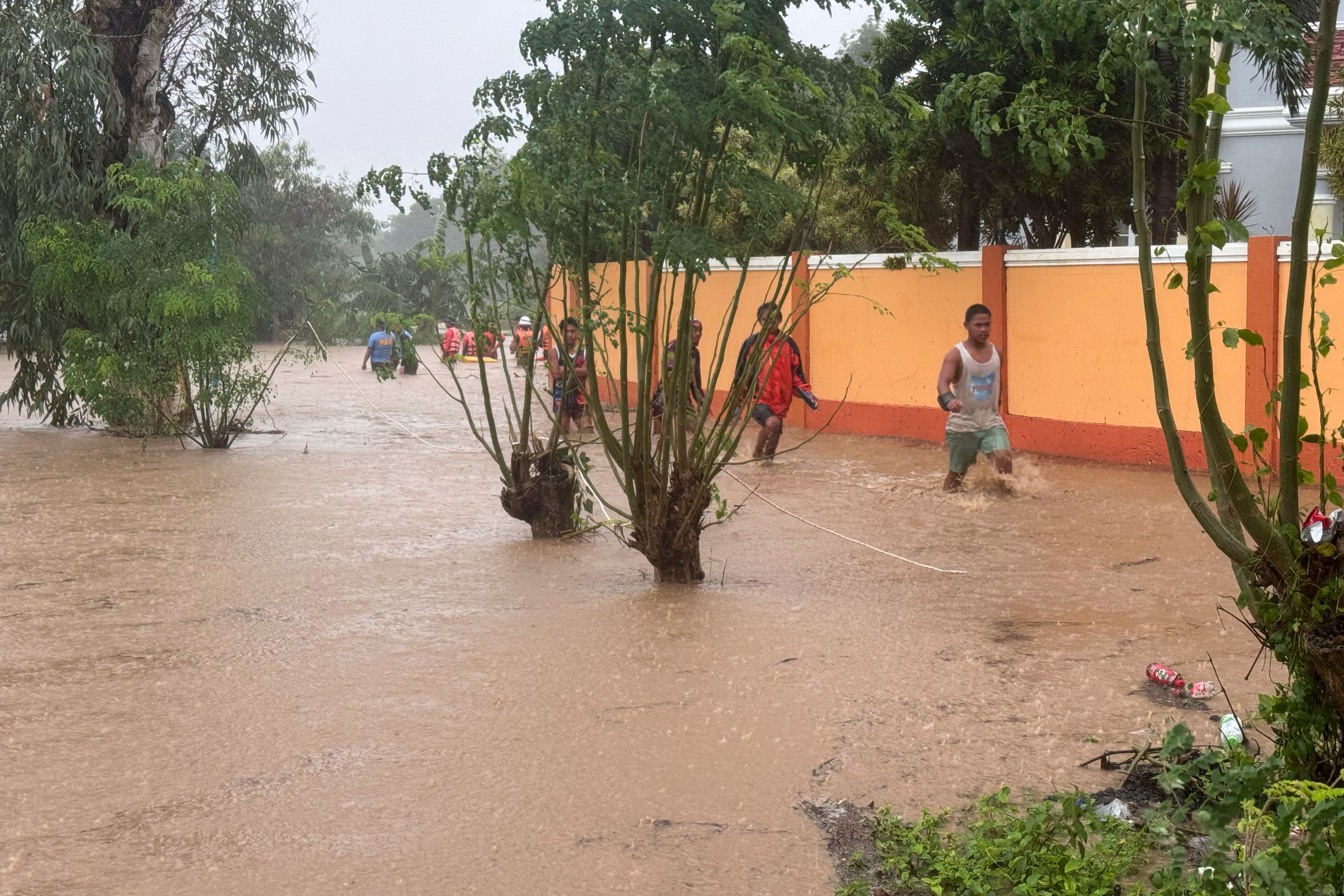 Residents negotiate floods caused by powerful Typhoon Krathon locally called "Typhoon Julian" at Bacarra, Ilocos Norte province, northern Philippines on Monday, Sept. 30, 2024. (AP Photo/Bernie Dela Cruz)