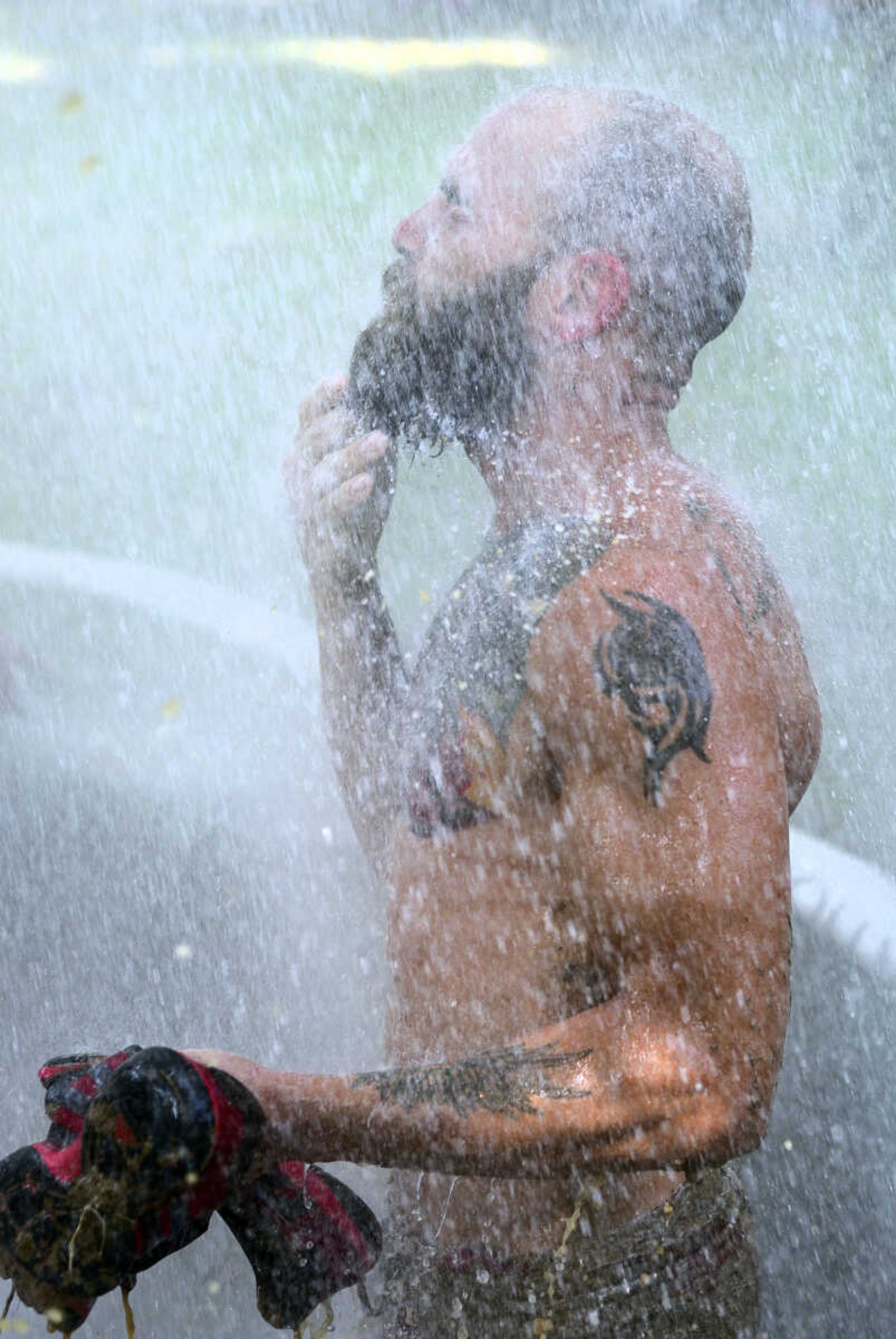 Jimmy Sievers washes off after a game of mud volleyball during the Fourth of July celebration on Tuesday at Jackson City Park.