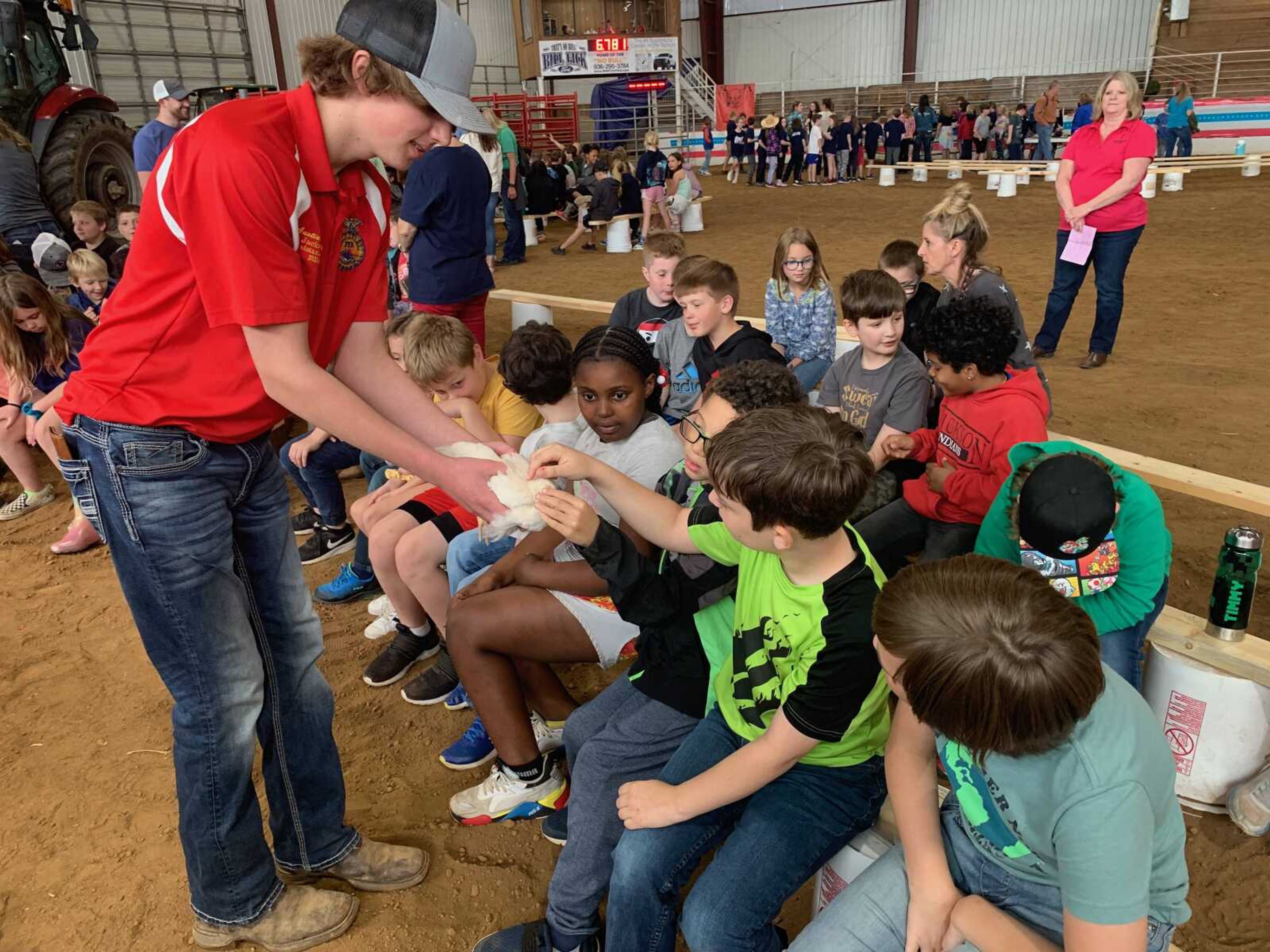 Austin Bodenstein holds a chicken for South Elementary students to pet after teaching them about poultry and eggs. Chickens swallow rocks to help break down food because they do not have teeth.