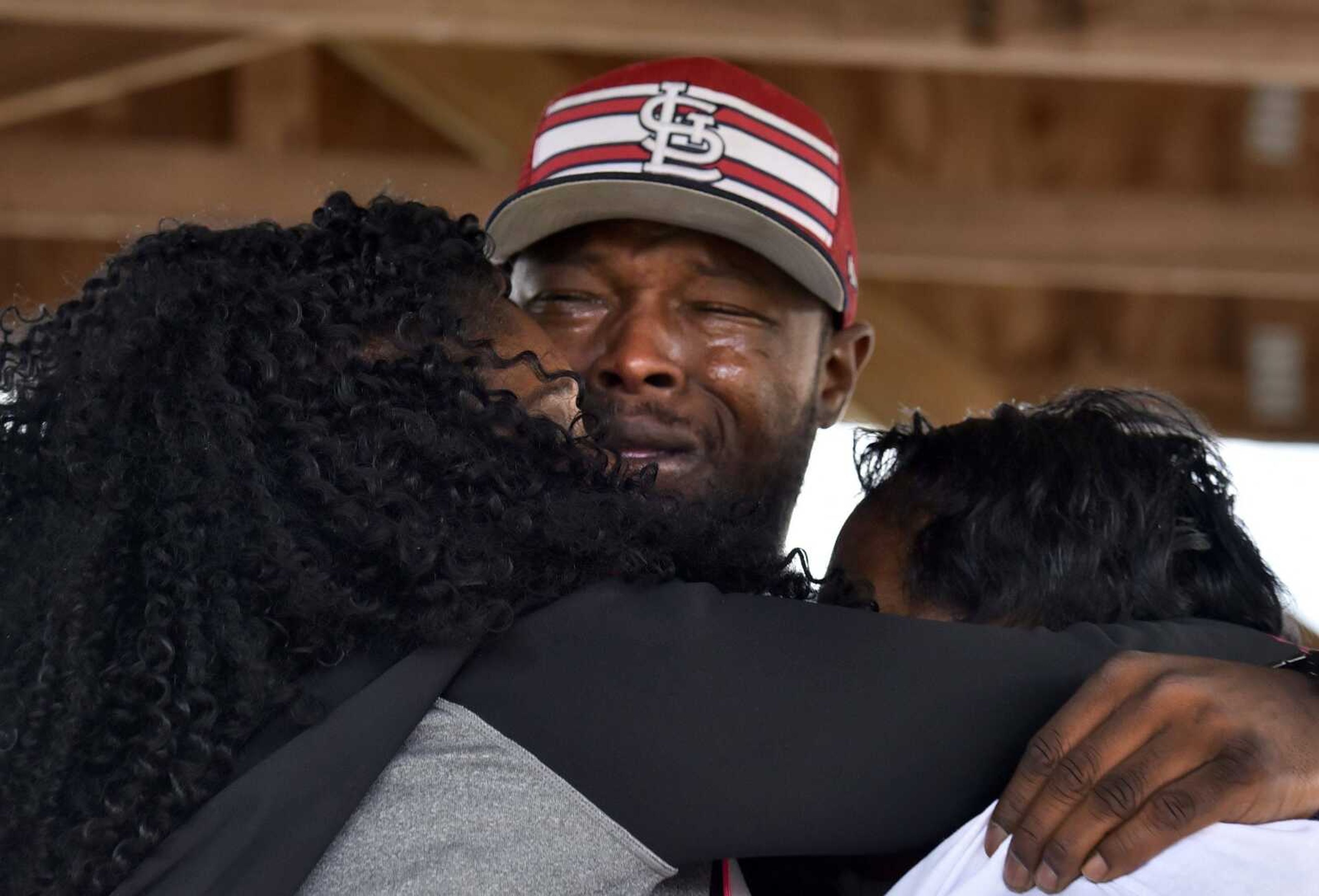 A tearful Justin Robinson, David Robinson's brother, embraces his mother, Jennett McCaster, right, and another family member on Saturday, Nov. 5, 2016 before the David Robinson Freedom March.