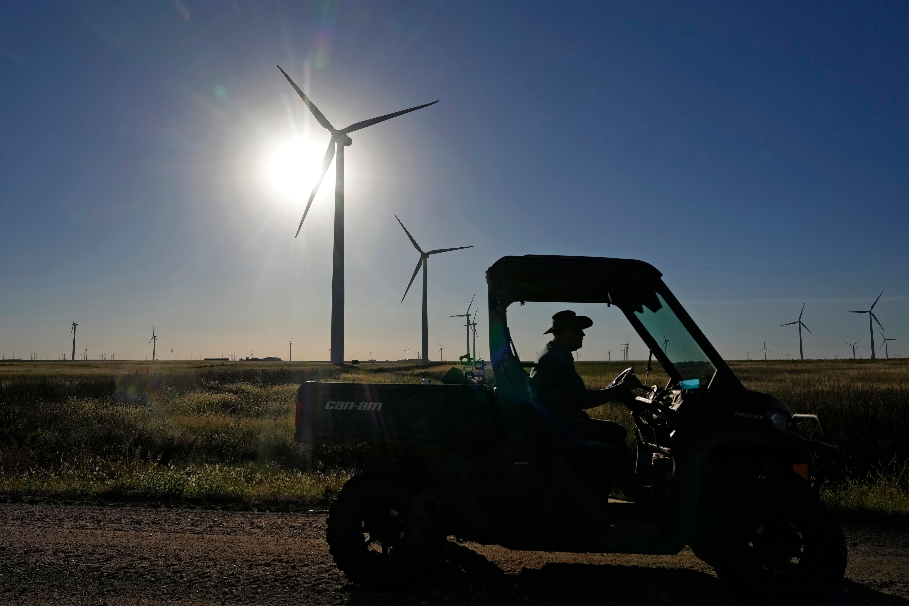 A farmer drives past wind turbines at the Spearville Wind Farm, Sunday, Sept. 29, 2024, near Spearville, Kan. (AP Photo/Charlie Riedel)