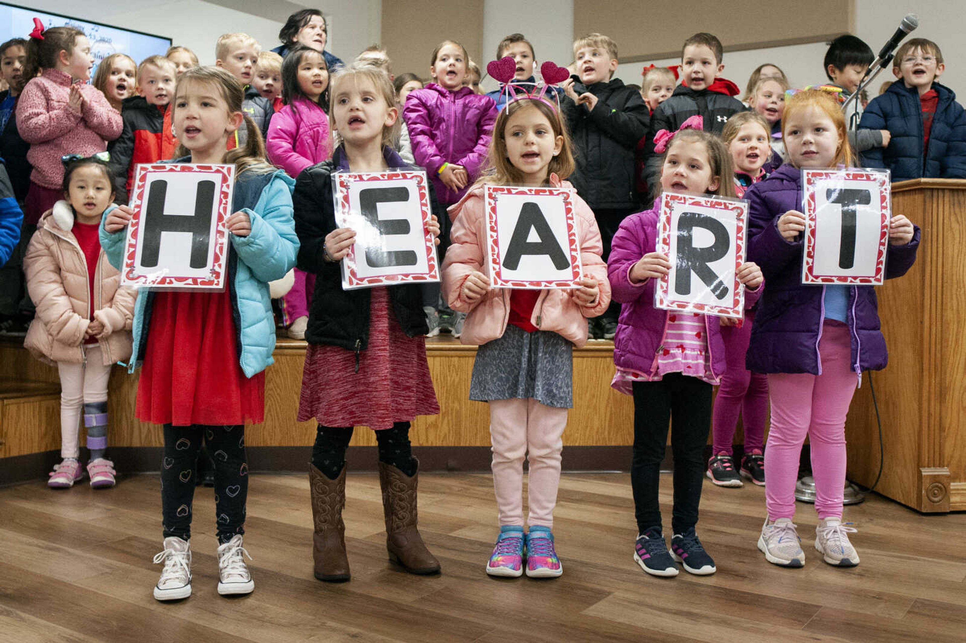 Holding signs from left: Callen Davison, Sadie Bengtson, Adeline Dillingham, Emory Bandermann and Ava Cook, all kindergarteners from Jackson's East Elementary School, sing "There is a heart that's filled with love" on Thursday, Feb. 13, 2020, at the Jackson Senior Center. Kindergarten teacher Jana Scott said there were about 90 students, from four kindergarten classes, who sang as part of a service project to reach out to and do something kind for the community. The students gave out valentine cards, which Scott said the students made, to people at the end of the program.