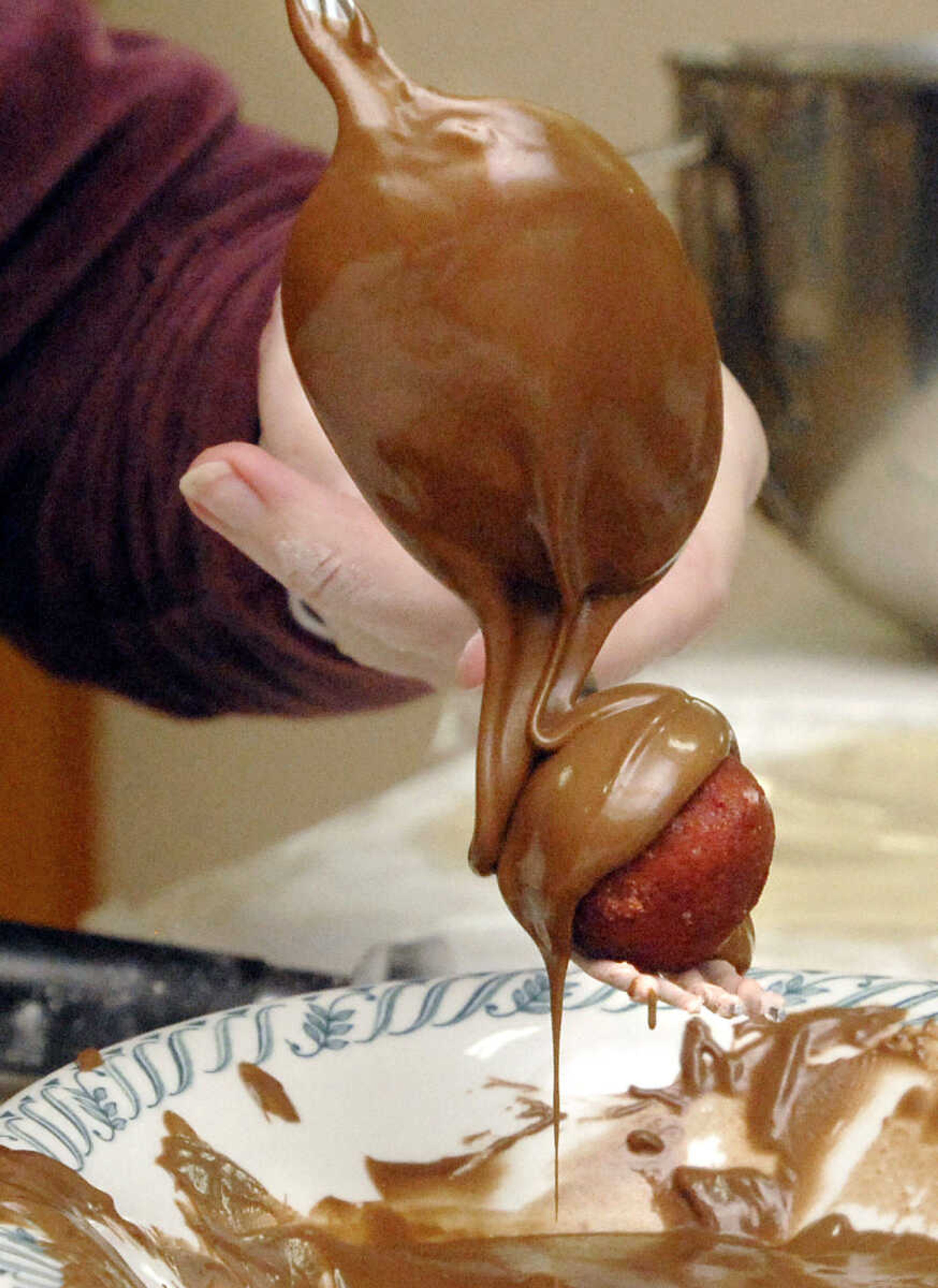 LAURA SIMON~lsimon@semissourian.com
Melted chocolate is drizzled over a red velvet cake ball Saturday, February 5, 2011.