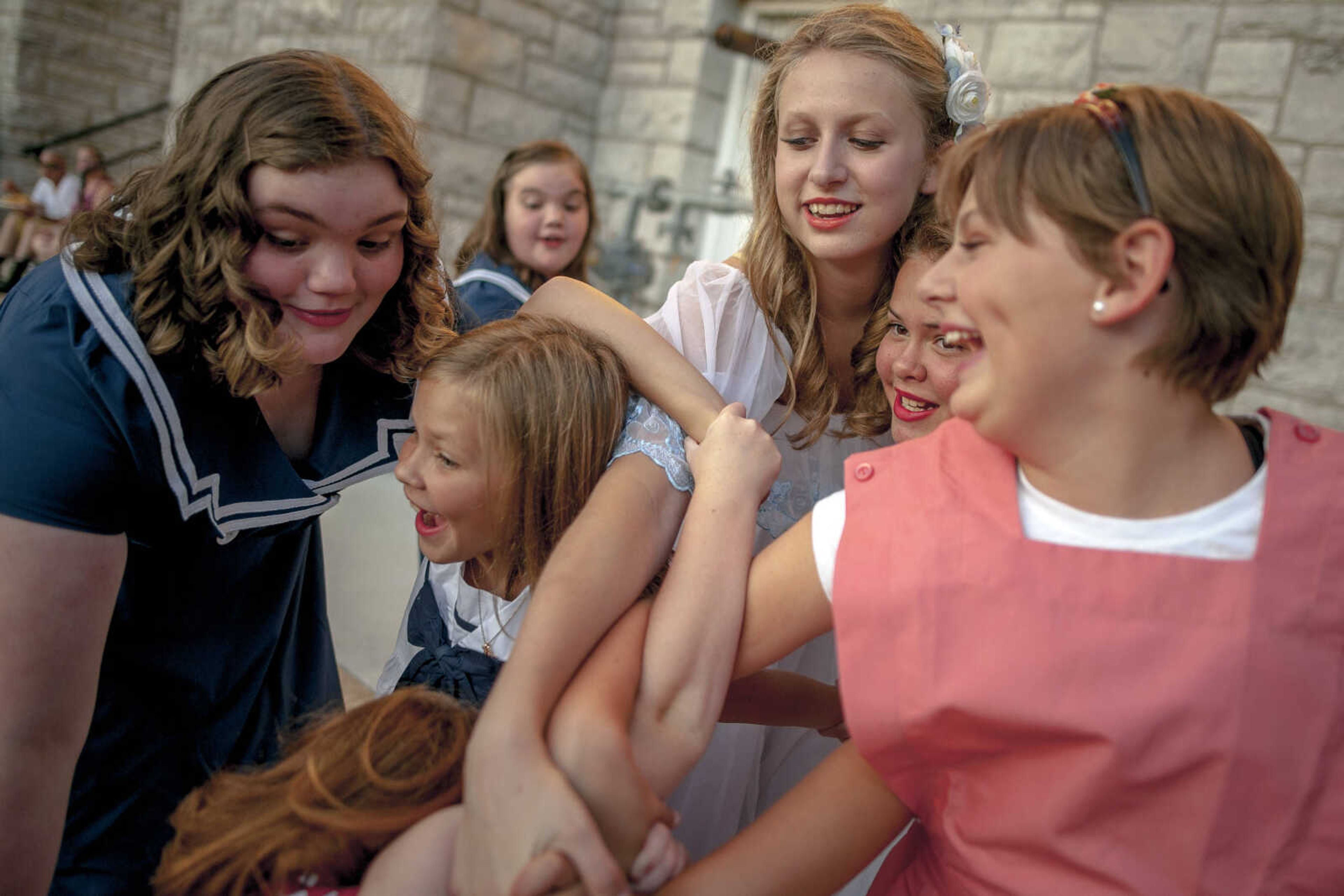 Actors from left, Kaitlyn Mulcahy, Molly Jacobs, Makenna Wessel, Carlie Jacobs and Eva Kilburn get tangled up while practicing dance moves before a USO-themed performance put on by Between the Scenes studio during Homecomers Tuesday, July 23, 2019, in Uptown Jackson.