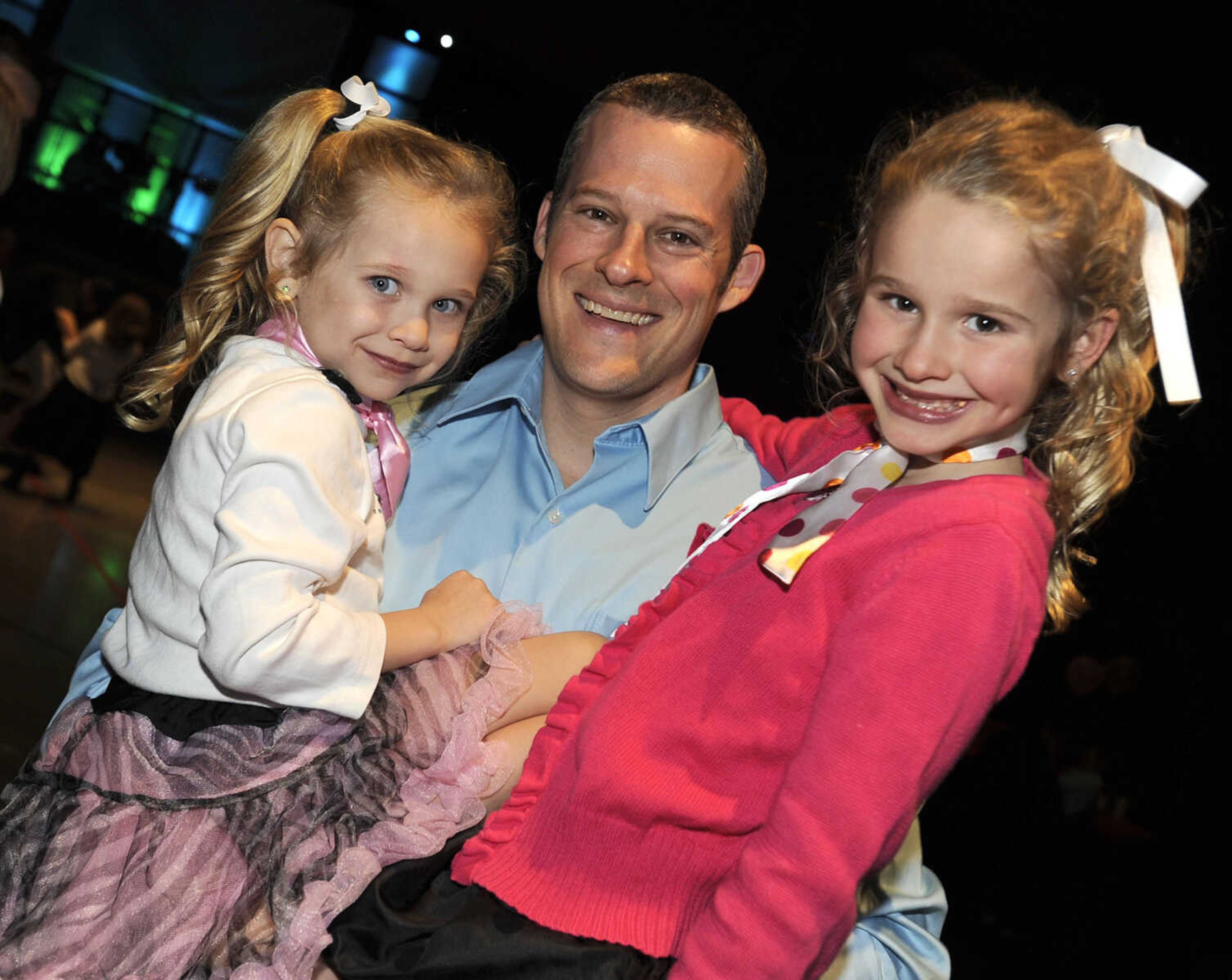 Matt Hollis and his daughters, Briley, left, and Maci, pose at the Me and My Guy Dance.