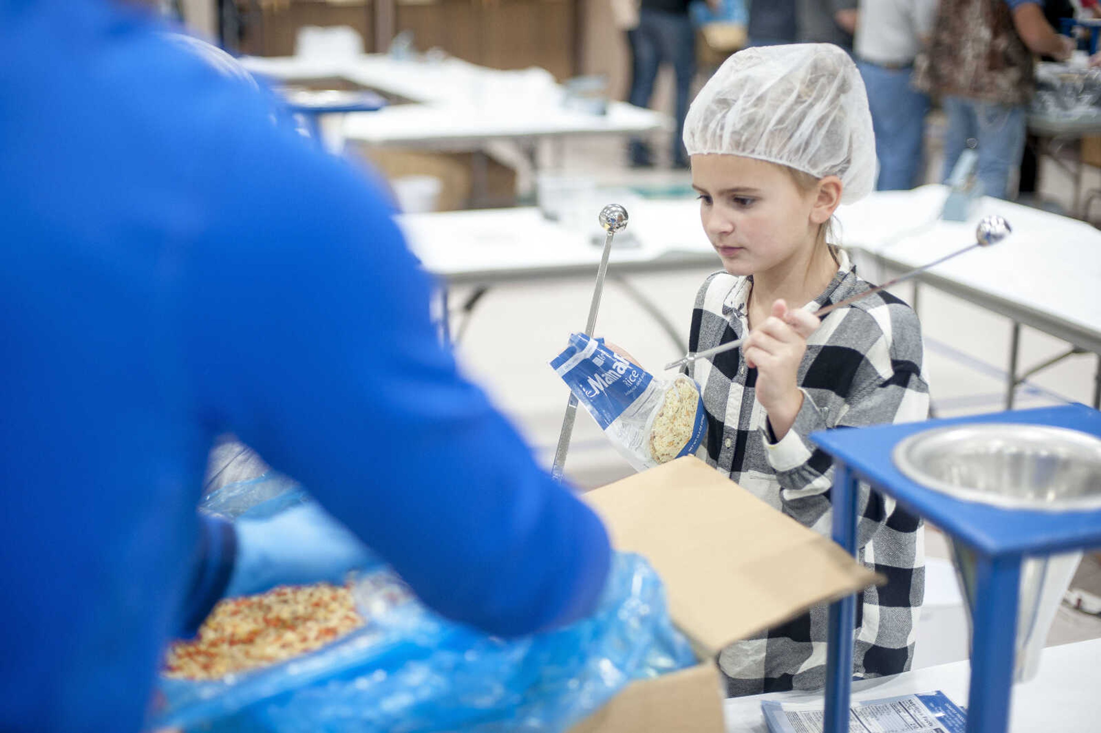 Volunteers pack containers with food during a Feed My Starving Children meal packing event hosted by La Croix Church Friday, Dec. 6, 2019, at the Osage Centre in Cape Girardeau.