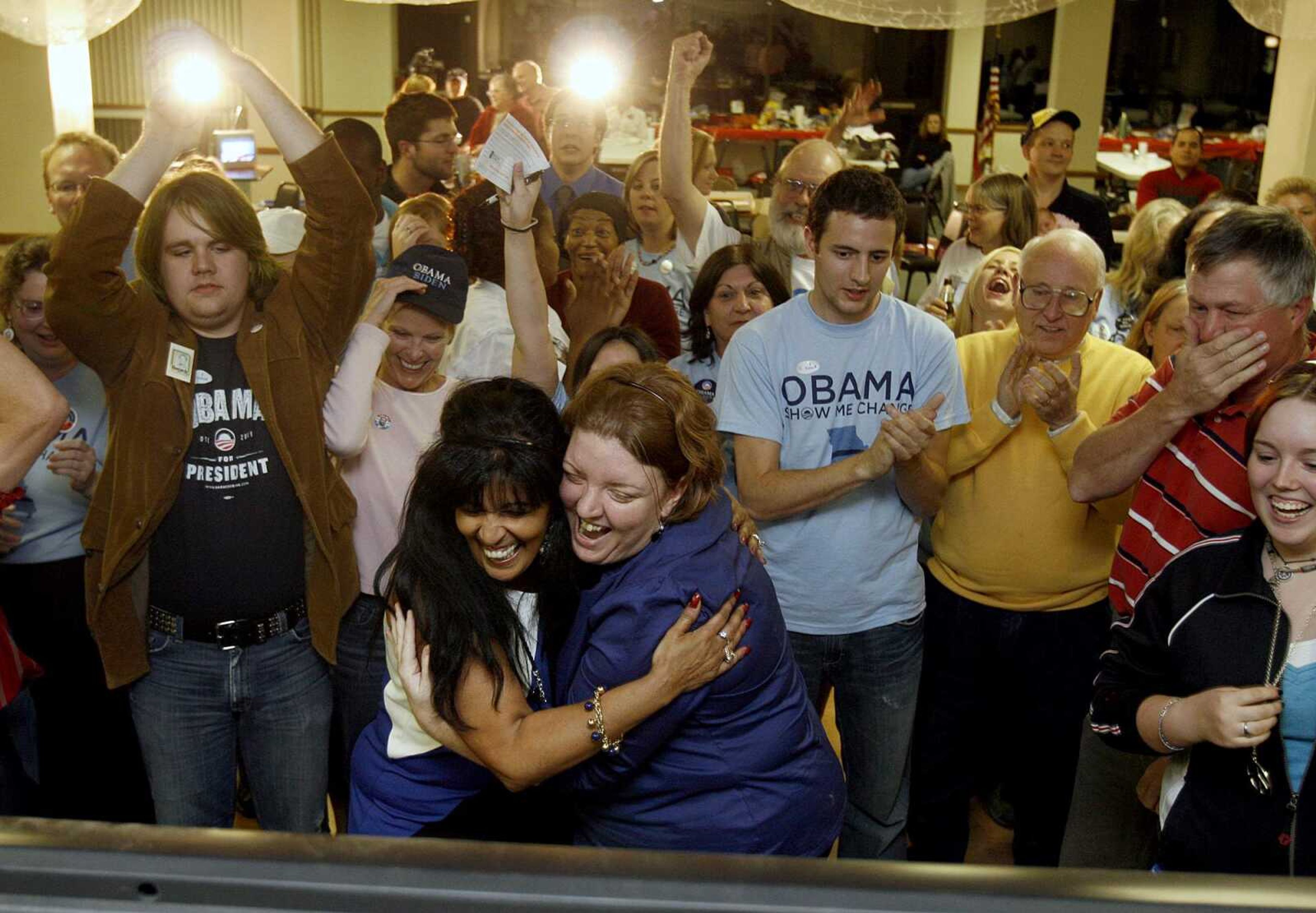 ELIZABETH DODD ~ edodd@semissourian.com
Debra Mitchell-Braxton, of Cape Girardeau, left, and Erin Gotto, of Cape Girardeau, share a moment in front of the television as Obama supporters continue to celebrate.