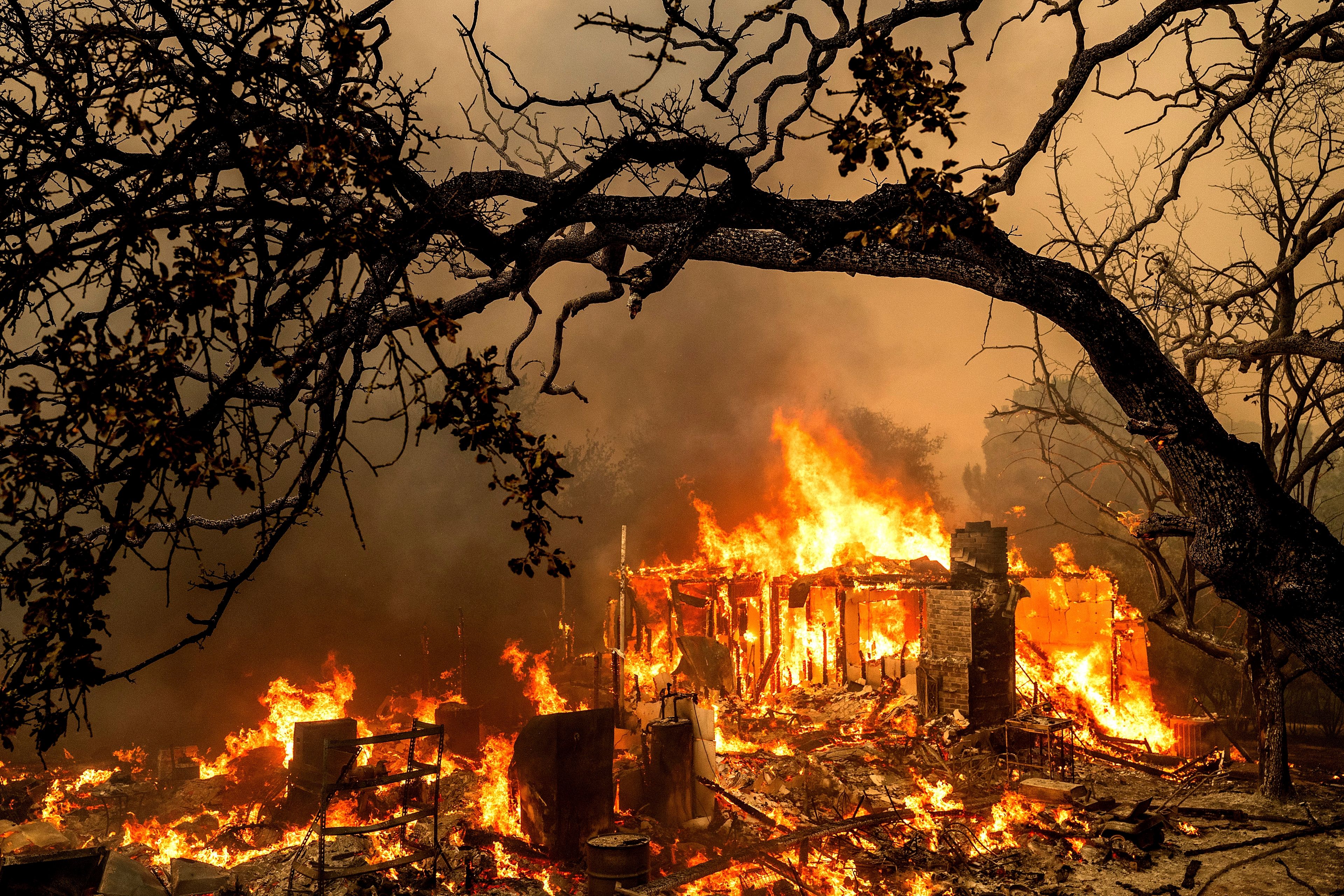 FILE - Flames consume a structure on Bessie Lane as the Thompson Fire burns in Oroville, Calif., July 2, 2024. (AP Photo/Noah Berger, File)