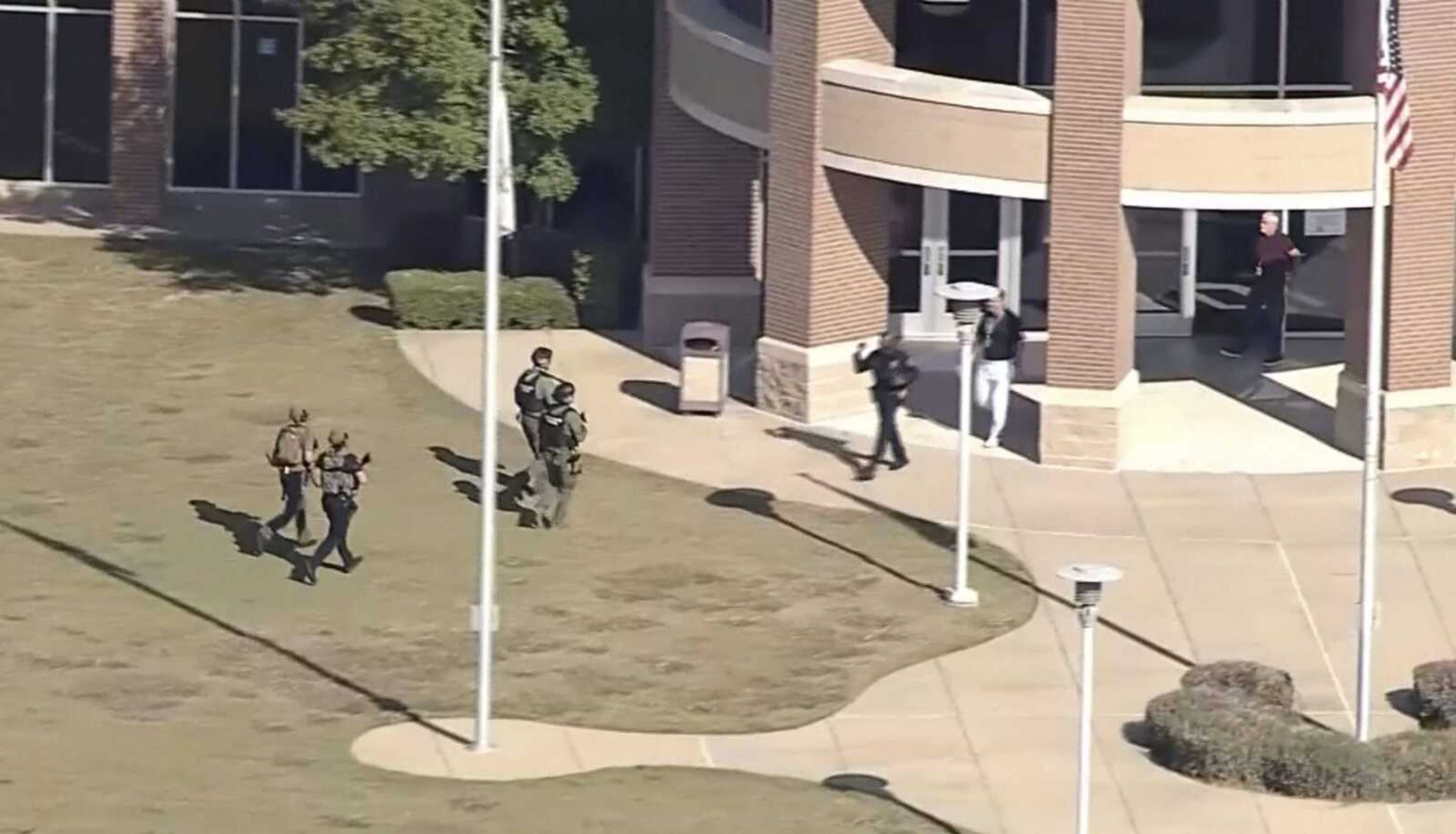 In this image from WFAA-TV video, law enforcement arrives at Timberview High School on Wednesday, Oct. 6, 2021 in Arlington, Texas. Authorities say a student opened fire inside the Dallas-area high school during a fight. 