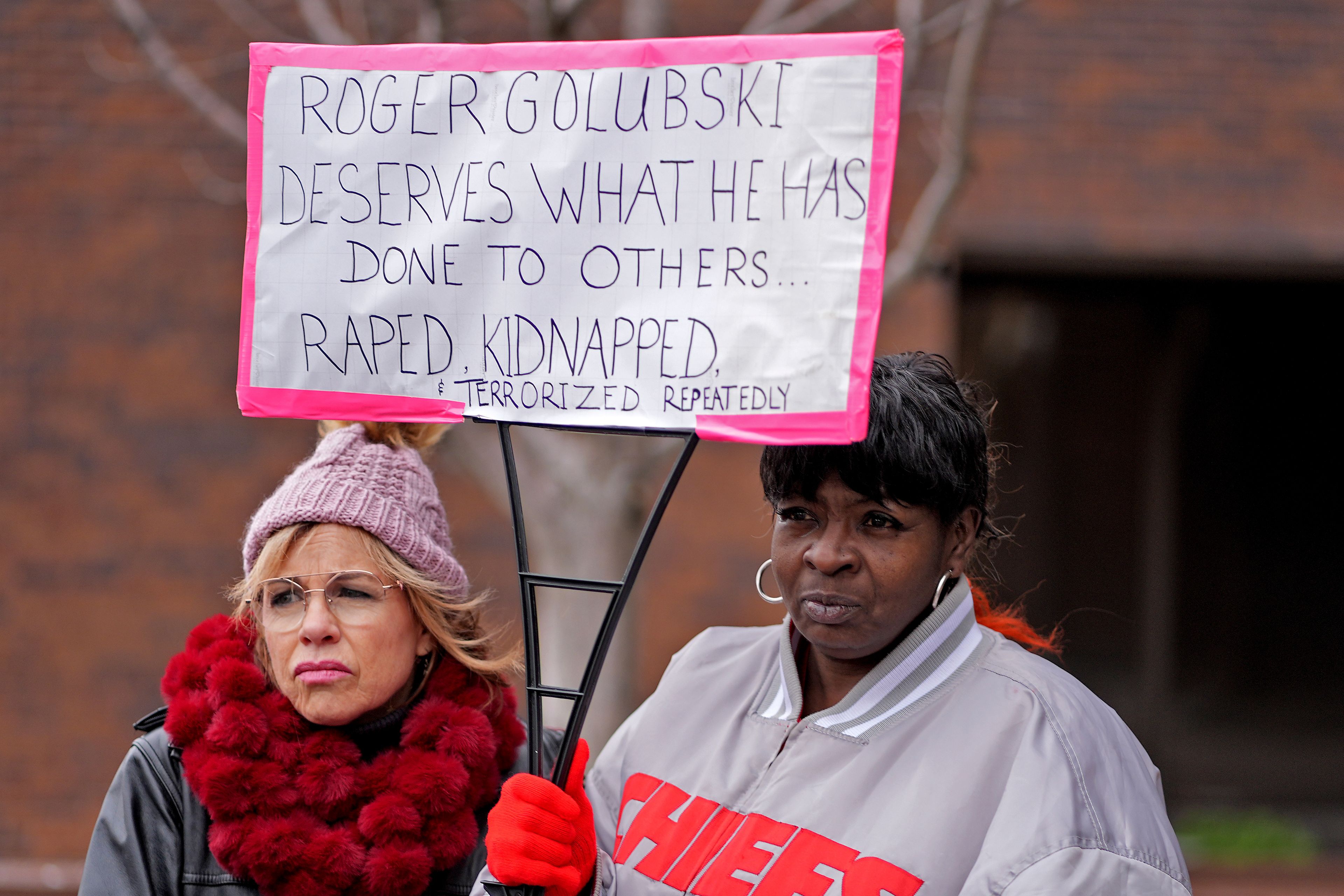 Lesa Mensa, left, and Anita Randle listen to a speaker at a rally outside the federal courthouse on was was to be the opening day for a trial for former police detective Roger Golubski, Monday, Dec. 2, 2024, in Topeka, Kan. (AP Photo/Charlie Riedel)