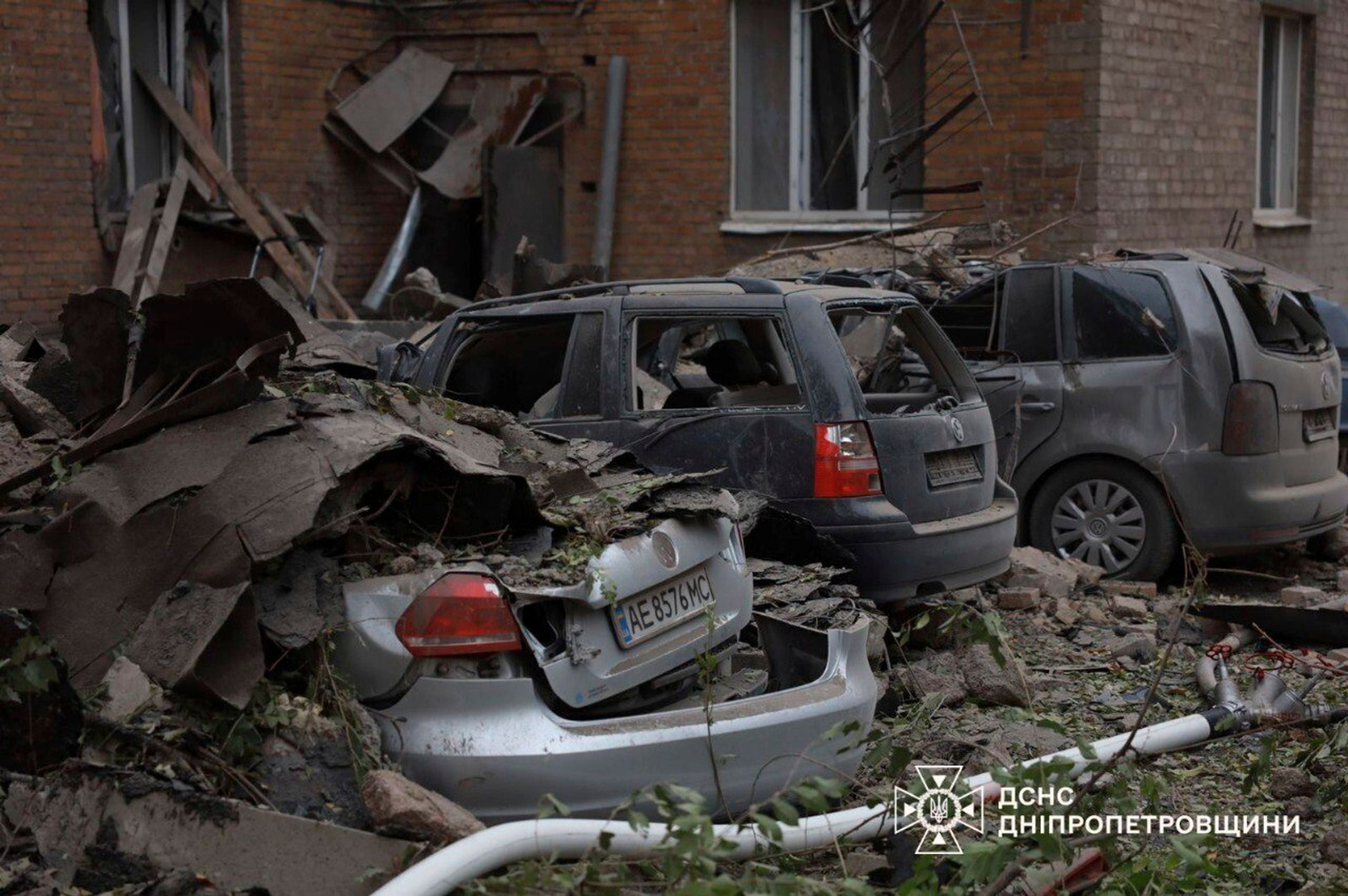 In this image provided by the Ukrainian Emergency Service on Monday, Nov. 11, 2024, damaged cars are seen in a yard of an apartments building destroyed by a Russian attack in Kryvyi Rih, Ukraine. (Ukrainian Emergency Service via AP)