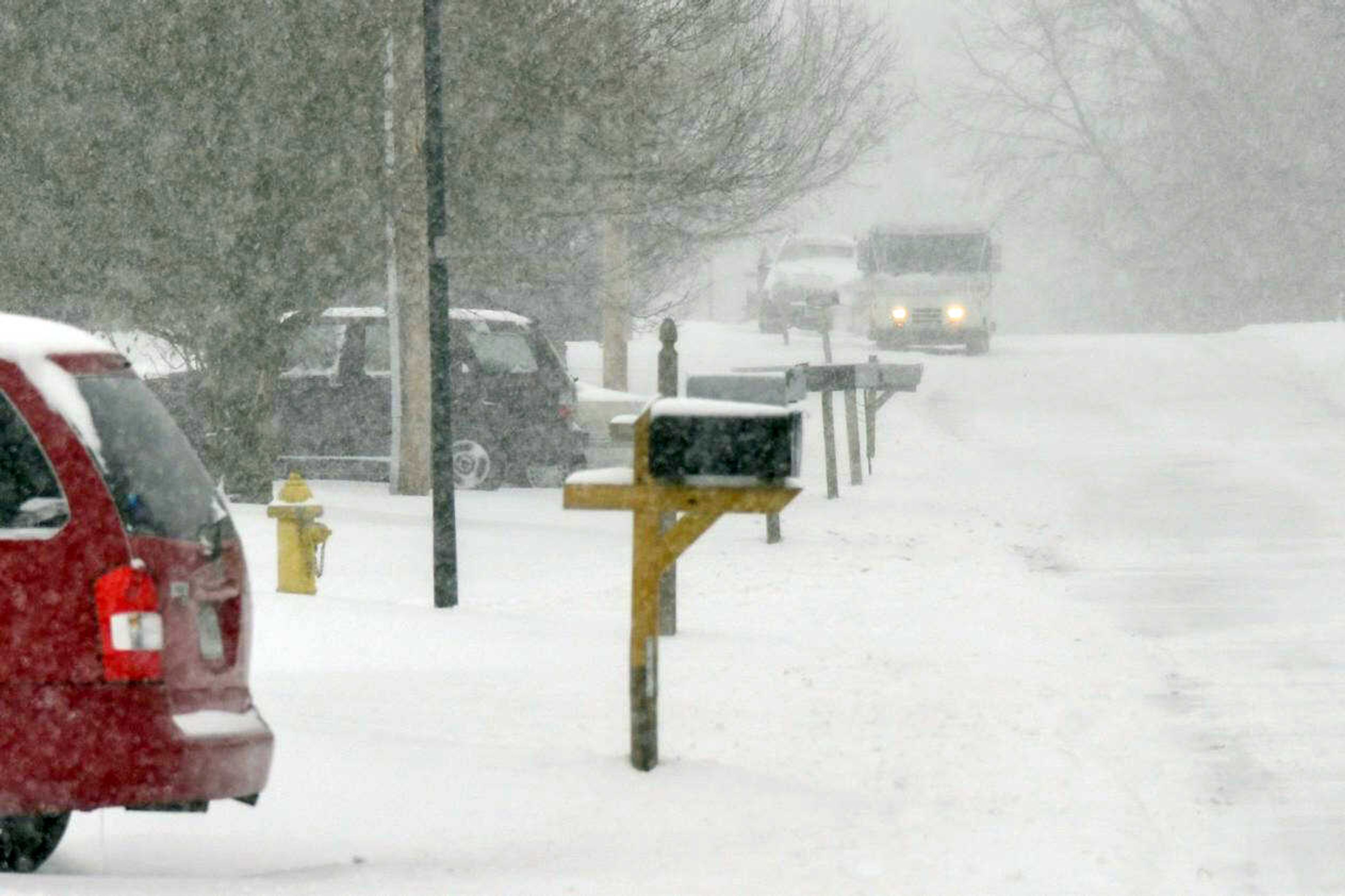 In the distance, a United States Postal Service vehicle delivers mail during a snow storm Monday in Cape Girardeau.