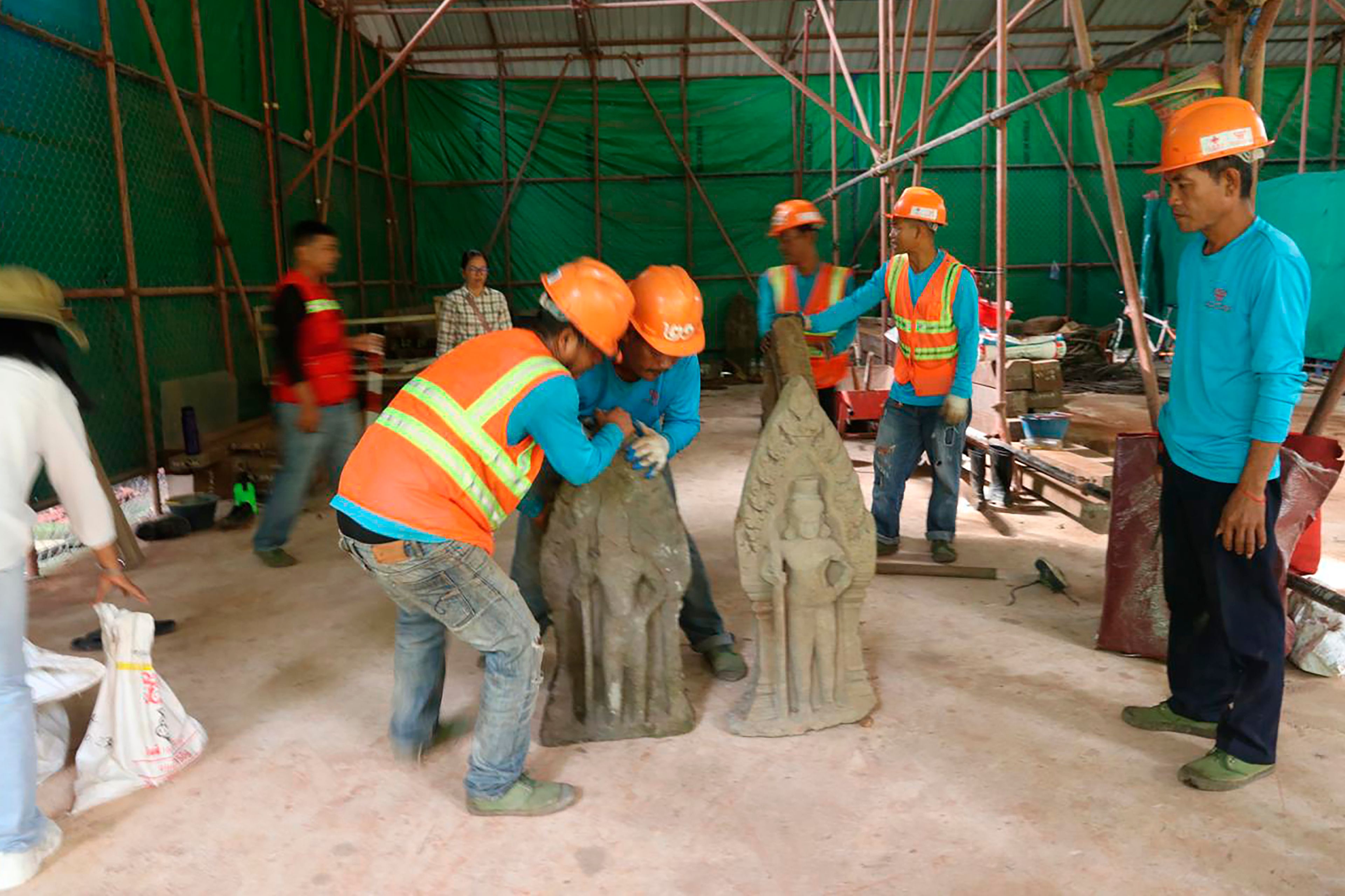 This handout photo provided by Apsaras National Authority shows centuries-old sandstone statues being arranged at Angkor Thom in Cambodia, Oct. 24, 2024. (Phouk Chea/Apsaras National Authority via AP)