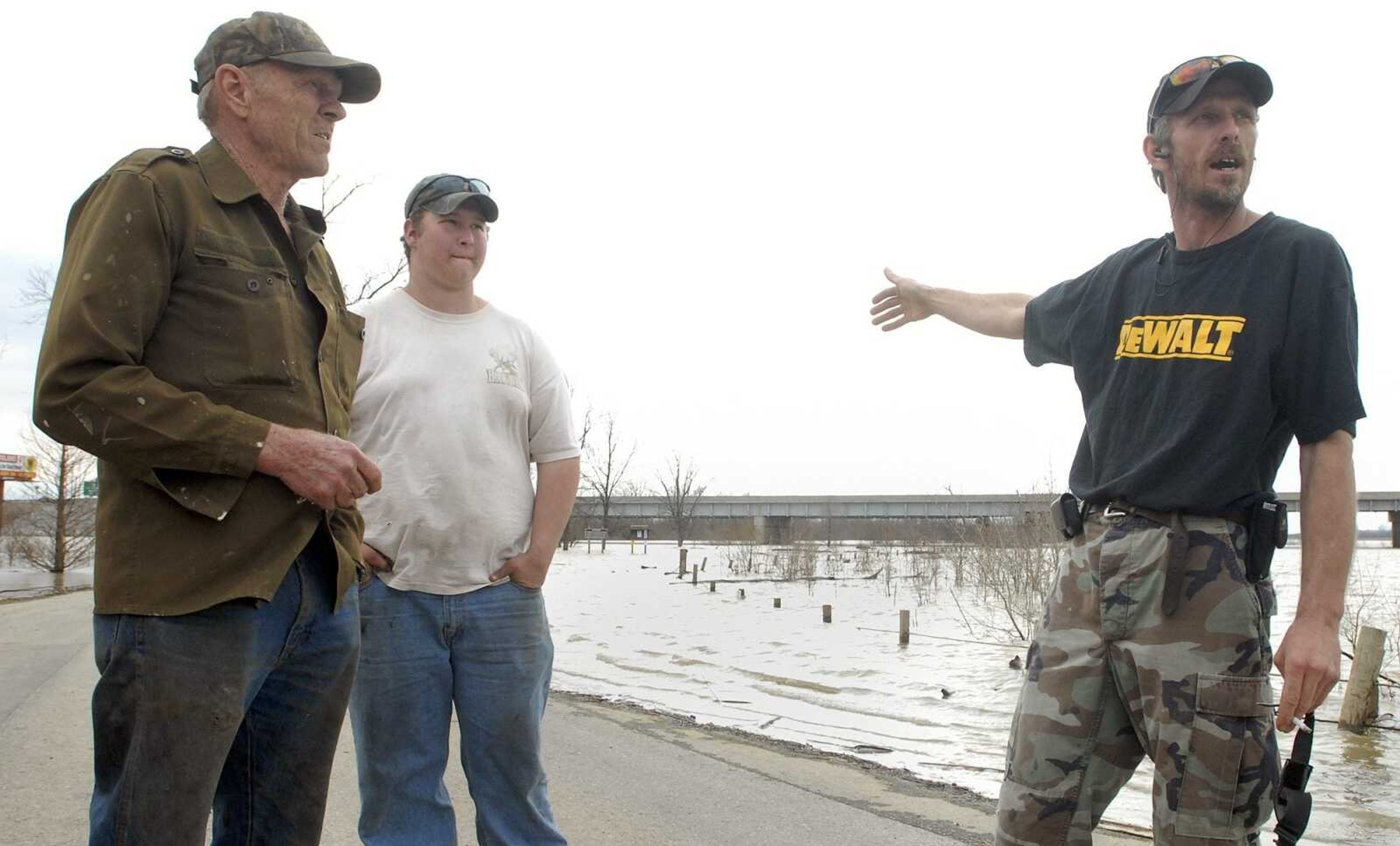 Richard Fischer, right, points to where a woman jumped from the I-55 bridge over the diversion channel Friday afternoon, March 18, 2011. Richard, his father Bob, left and Bob's grandson Nathan Vomund were fishing from their boat in the channel when the woman jumped. They rescued her from the waters. (Laura Simon)