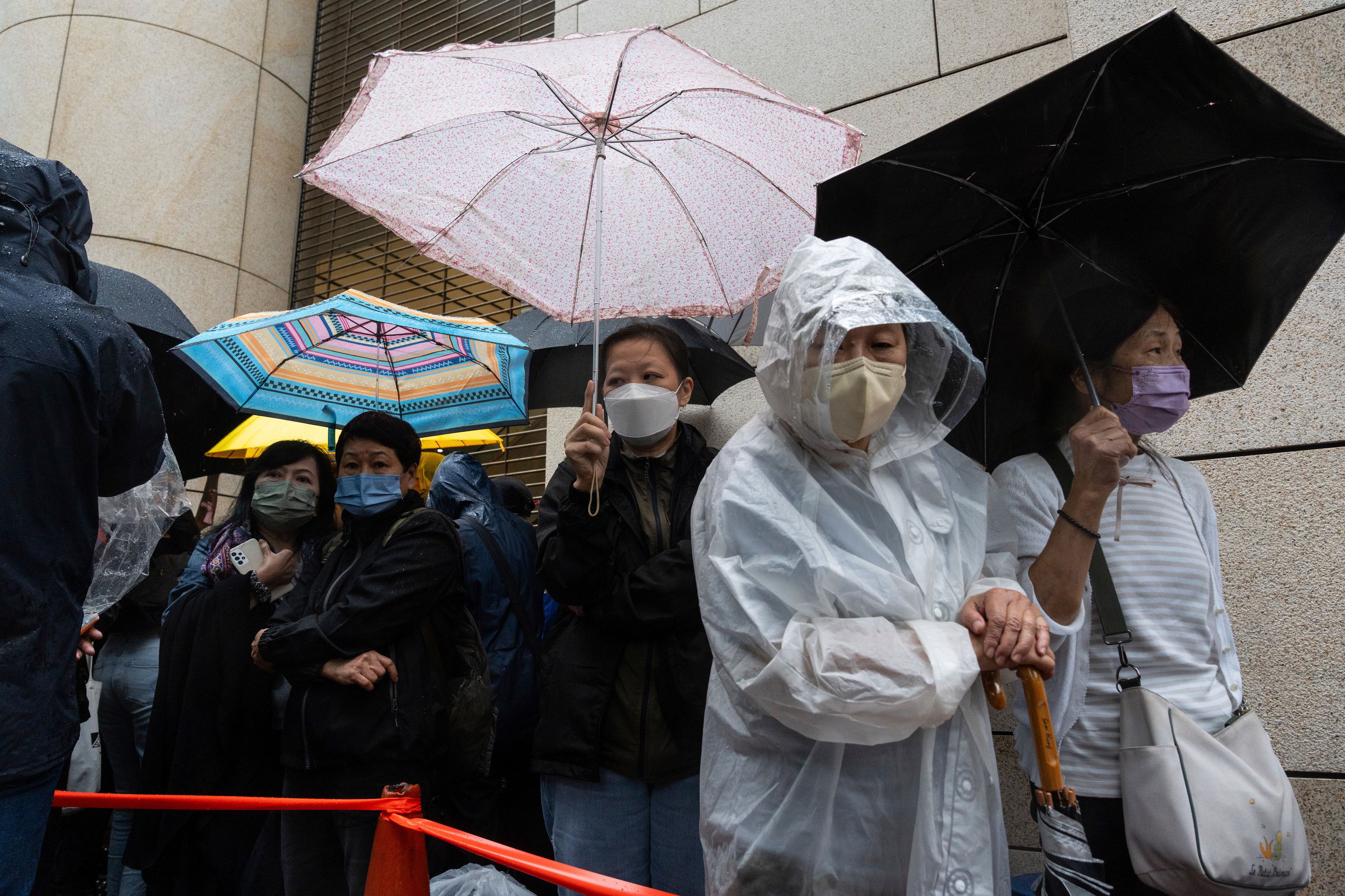 People wait outside the West Kowloon Magistrates' Courts in Hong Kong Tuesday, Nov. 19, 2024, ahead of the sentencing in national security case. (AP Photo/Chan Long Hei)