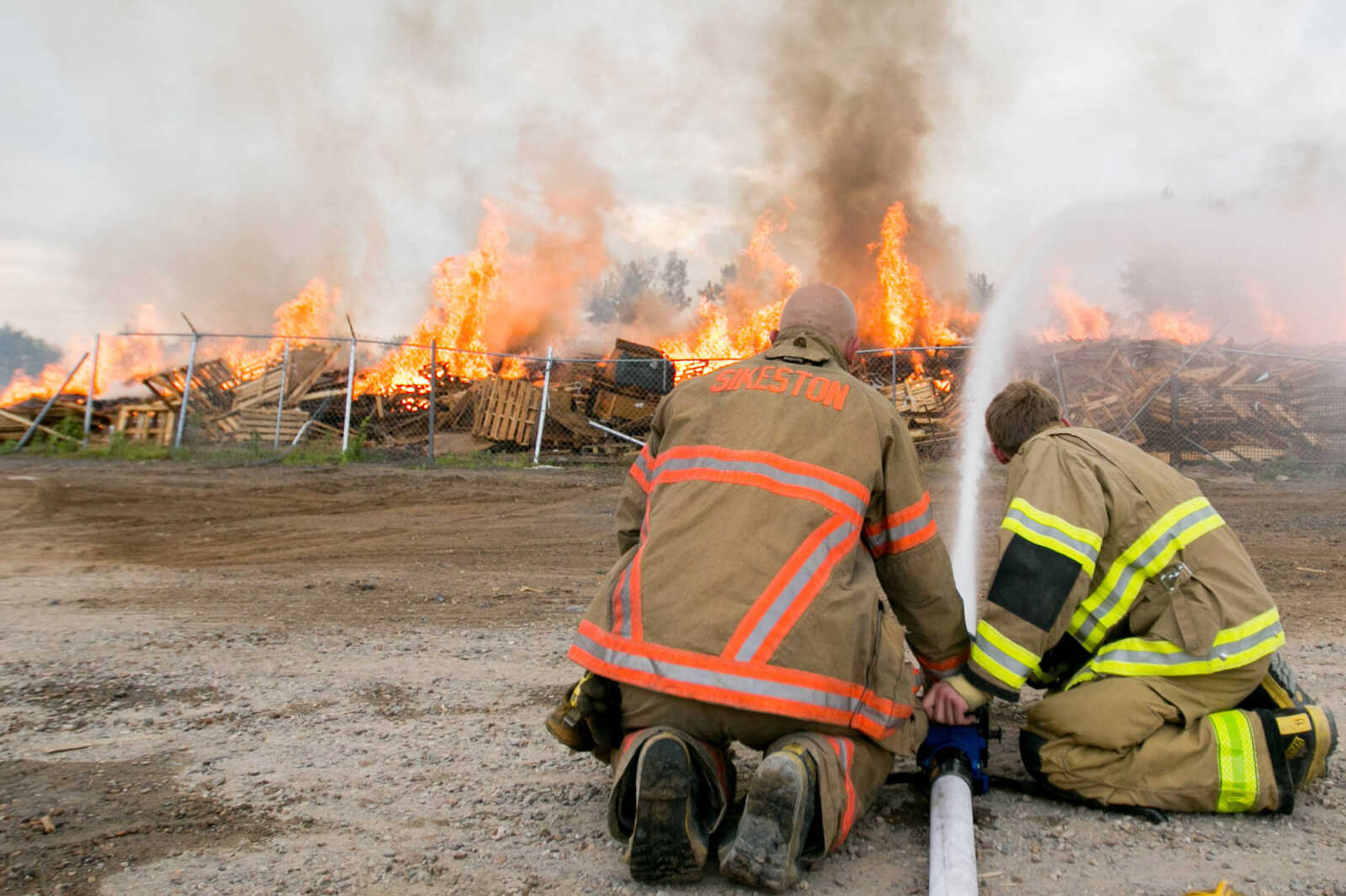 Firefighters with the Sikeston, Missouri, Department of Public Safety work with other area fire crews to extinguish a blaze Friday at Pallet Connections on Route H in Scott County. (Glenn Landberg)