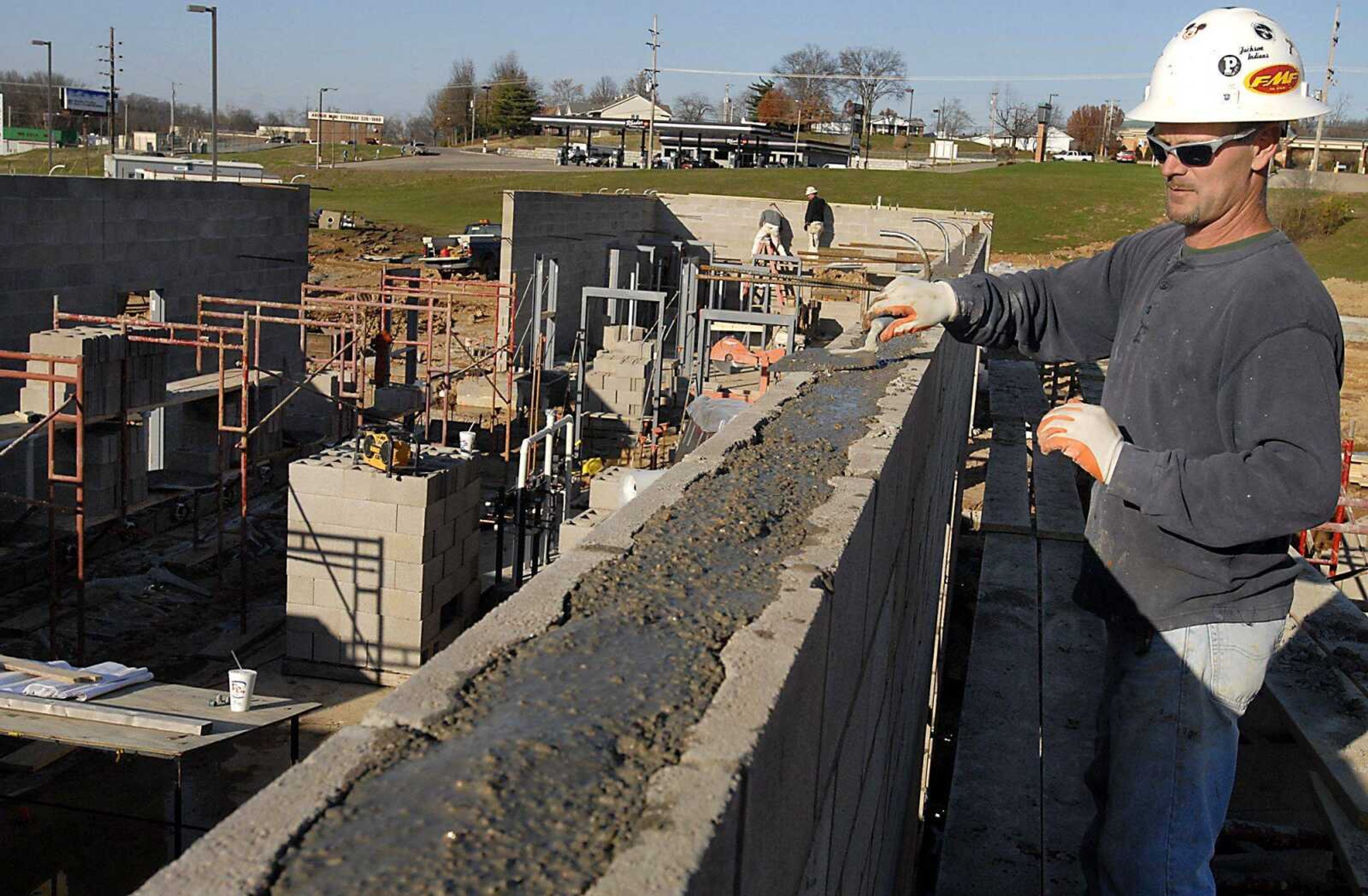 Ricky Pecaut levels grout on the top of the shower and restroom facility of the Family Aquatic Center Monday, November 30, 2009, at Osage Park in Cape Girardeau. (Kit Doyle)