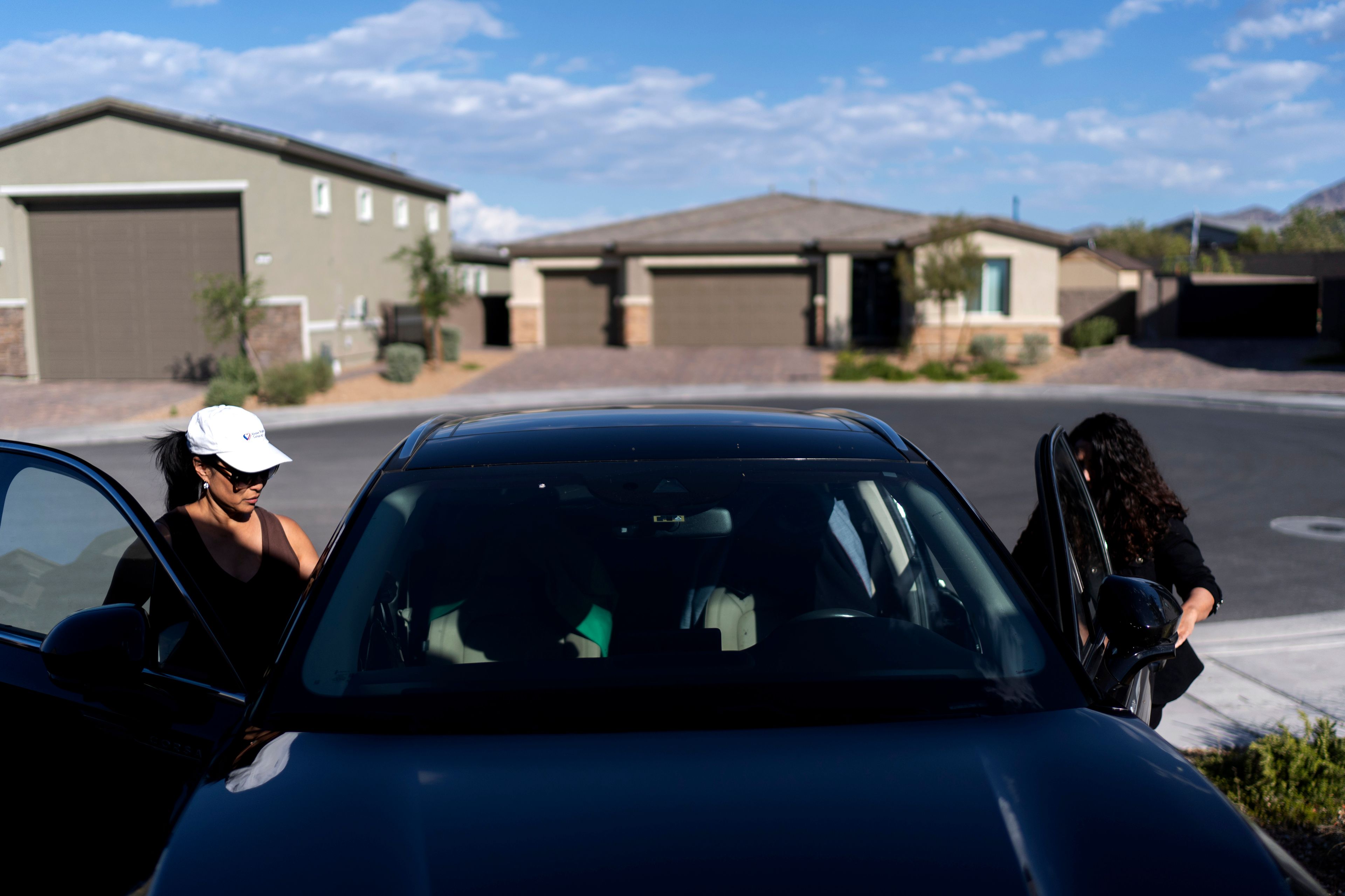 Joy Alessi, left, and fellow adoptee Buttons, get in a car as they leave Alessi's home Monday, June 24, 2024, in Henderson, Nev. Alessi anointed her friend Buttons "an honorary Korean." This problem they have both endured was born there, in Alessi's motherland, and to her it represents the most glaring example of the neglectful system that brought them here. (AP Photo/David Goldman)