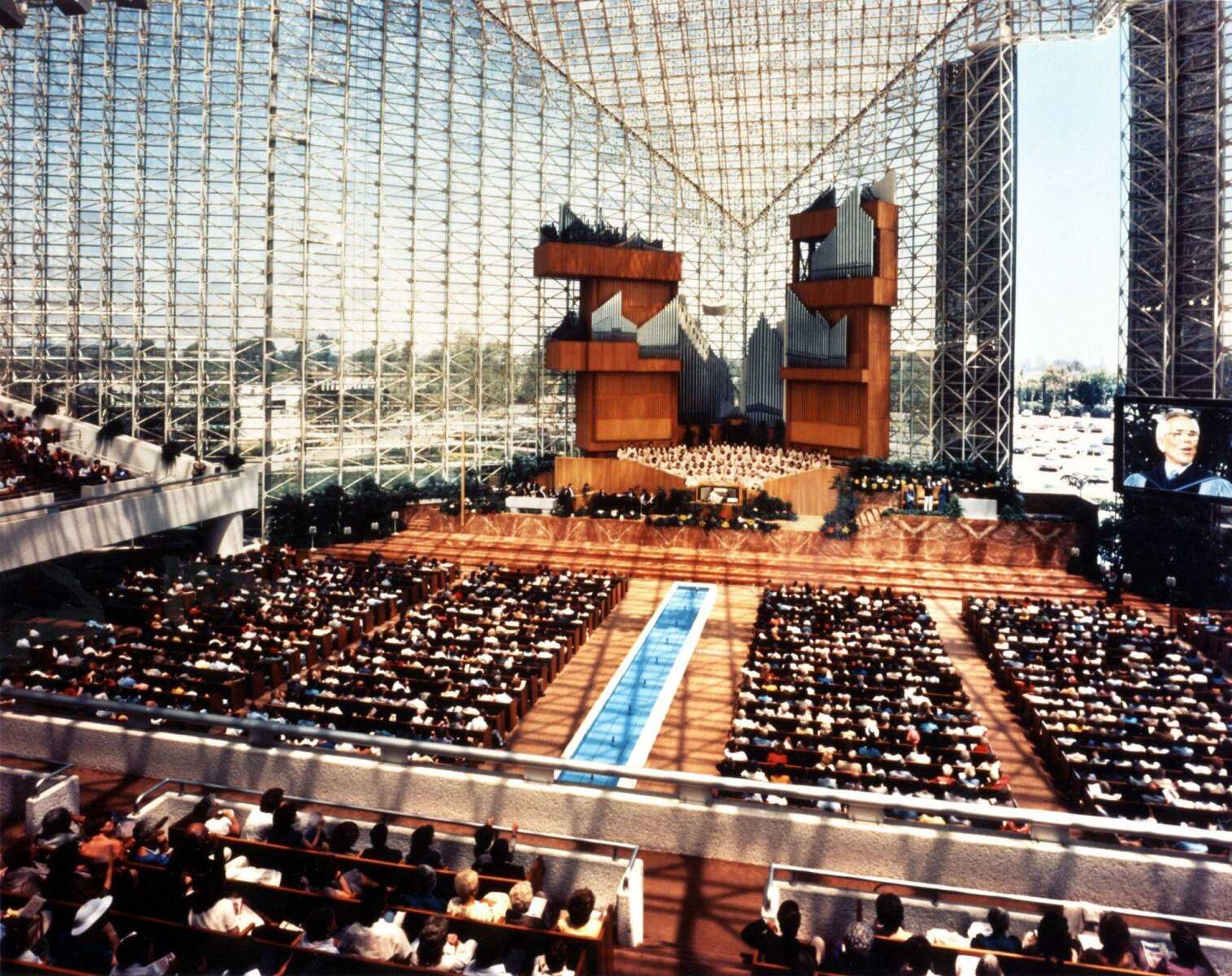 The Rev. Robert Schuller is seen on the large monitor, right, inside the Crystal Cathedral in Garden Grove, Calif. The Crystal Cathedral declared Chapter 11 bankruptcy this week. (Crystal Cathedral photo)