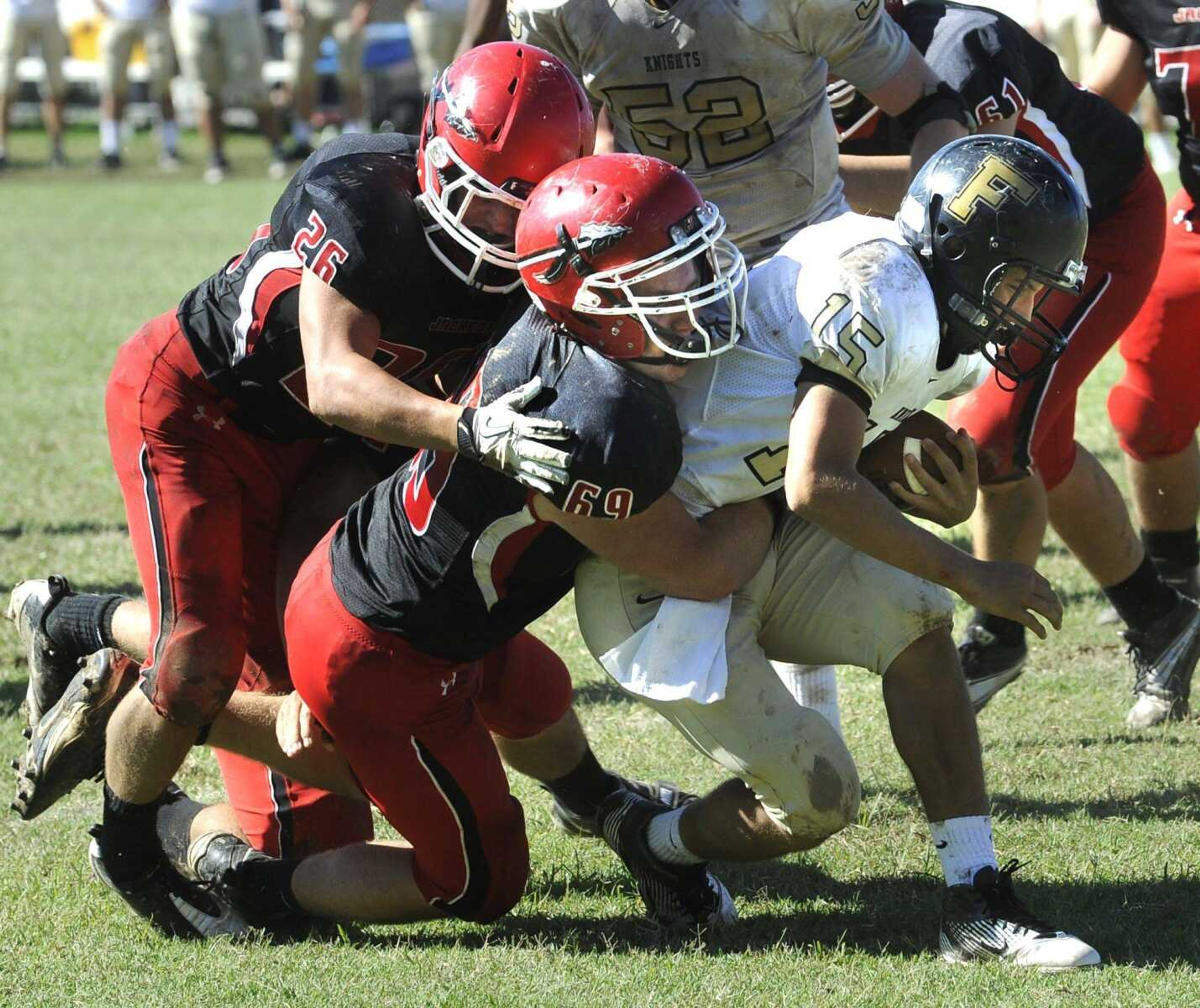 Jackson defenders Garrett Miller, left, and Garrett Koch prepare to tackle Farmington quarterback Justin Boehm during the third quarter Saturday at Jackson High School. (Fred Lynch)