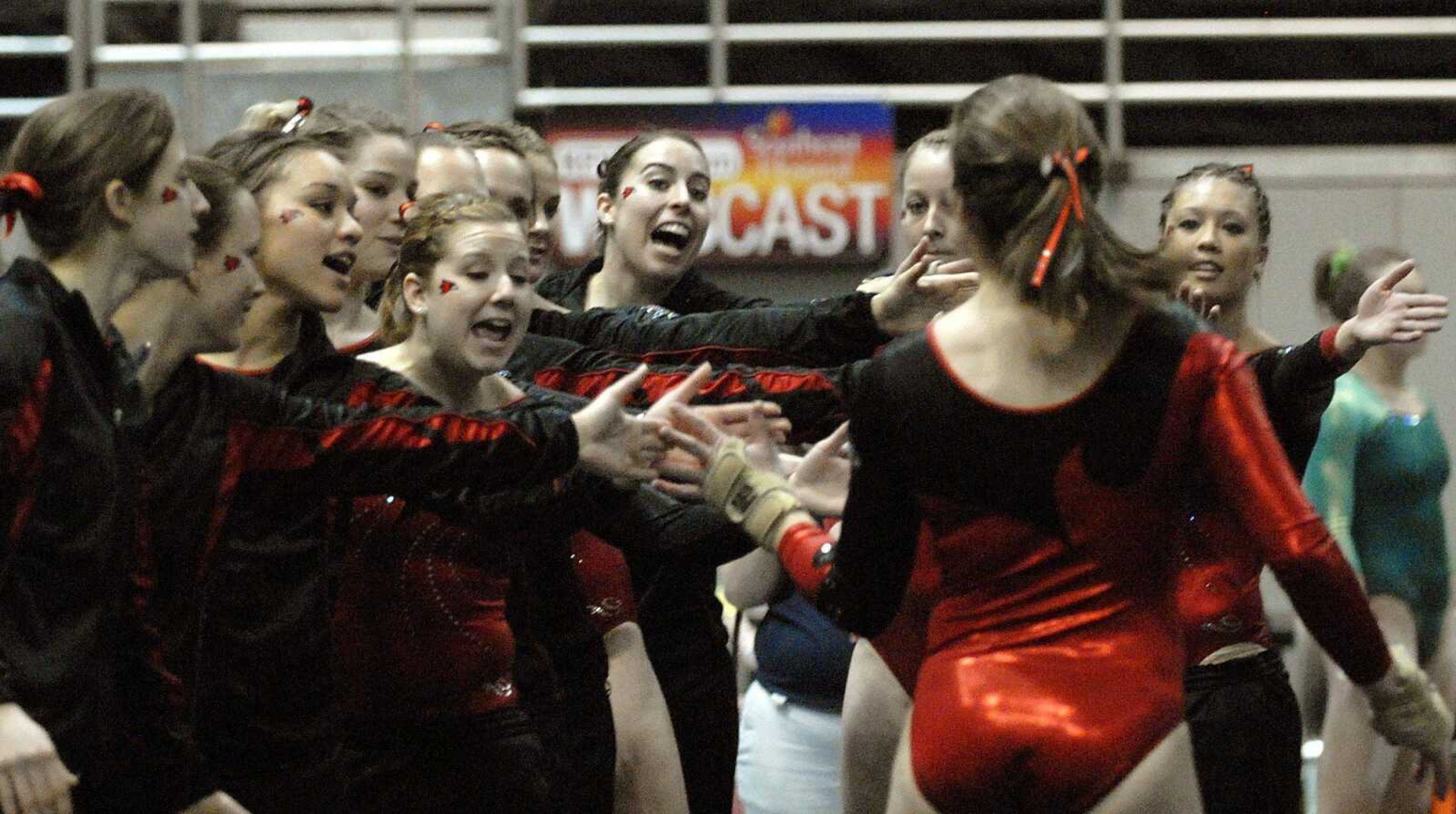 Southeast Missouri State gymnasts congratulate Emma Garrett after her floor excercise routine Sunday at the Show Me Center. Southeast posted the highest team score in the event. (LAURA SIMON)