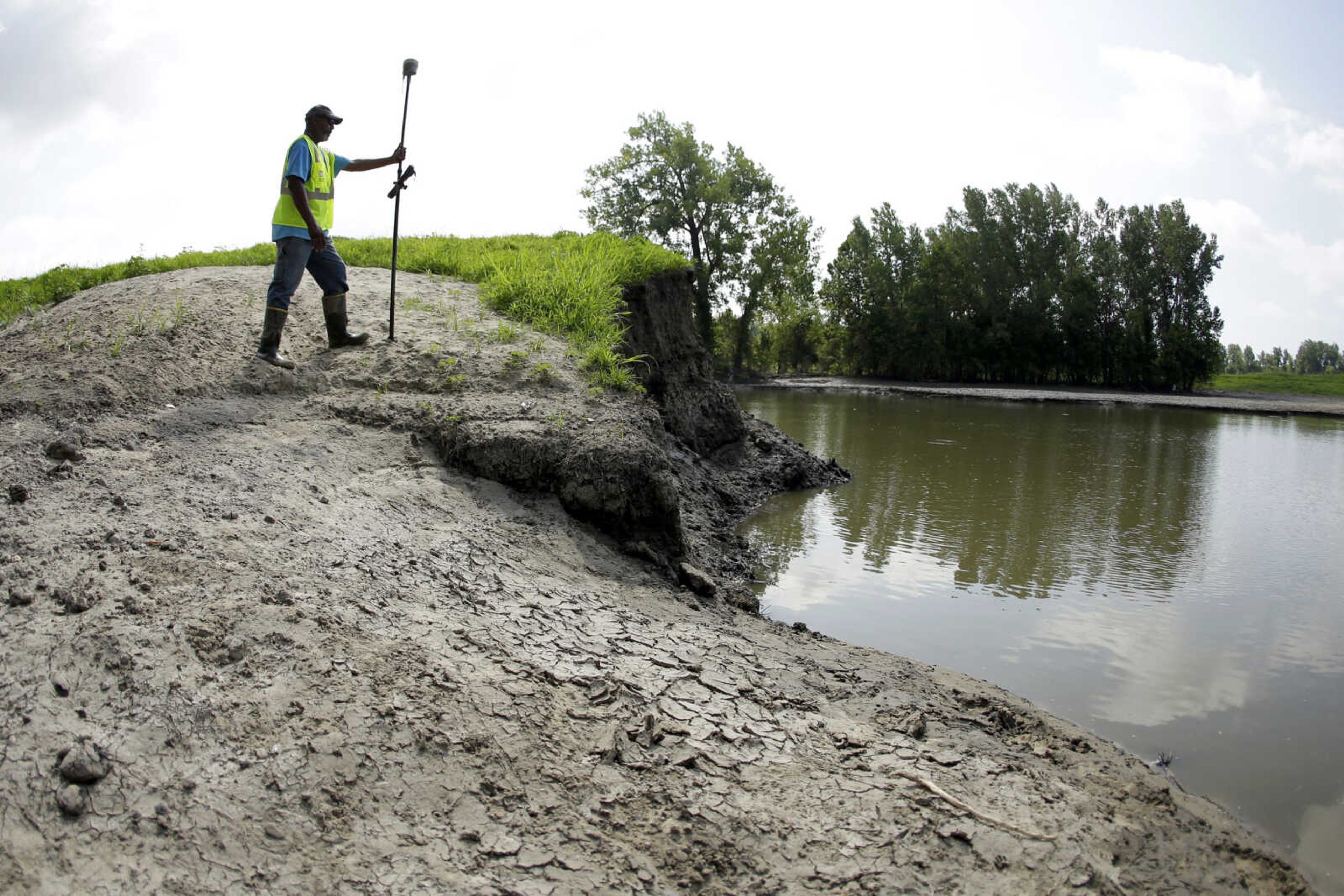 U.S. Army Corps of Engineers worker Ron Allen uses a GPS tool Tuesday to survey the extent of damage where a levee failed along the Missouri River near Saline City, Missouri. Efforts to fight rising waters may turn out to be only down payments on what is shaping up as a long-term battle against floods, which are forecast to become more frequent and destructive as global temperatures rise.