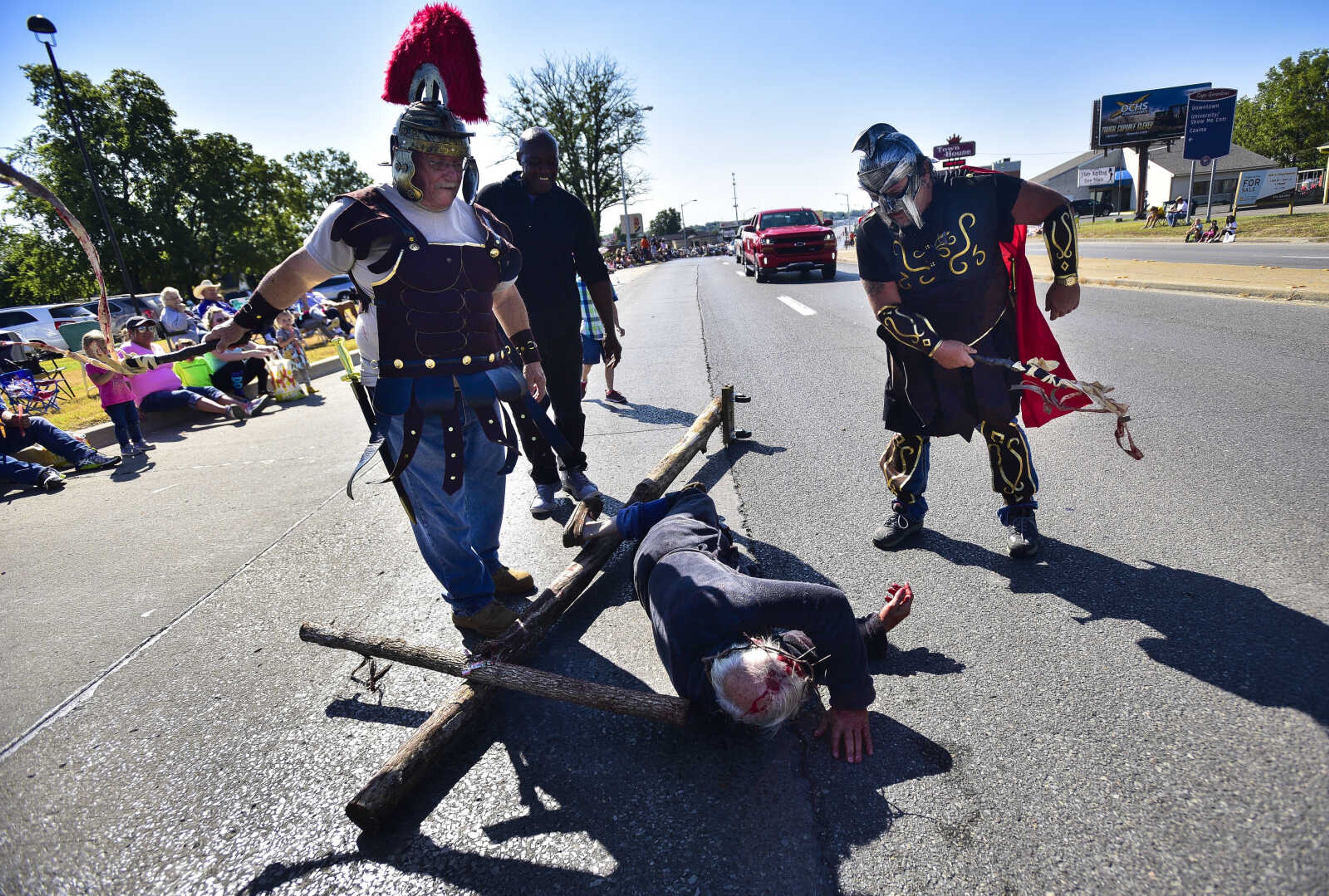 Floyd Penny, 78, with the Church of God Fellowship falls onto Broadway as he portrays Jesus Christ during the SEMO District Fair parade Saturday, Sept. 9, 2017 in Cape Girardeau.