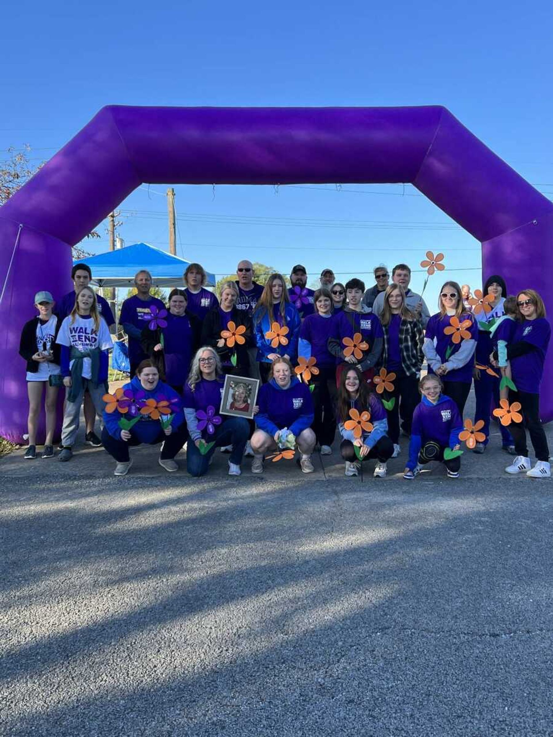 Walk to End Alzheimer's participants hold up orange flowers, which symbolize support for the cause and a vision for a world without dementia. This year's walk takes place at Capaha Park on Saturday, Oct. 19.
