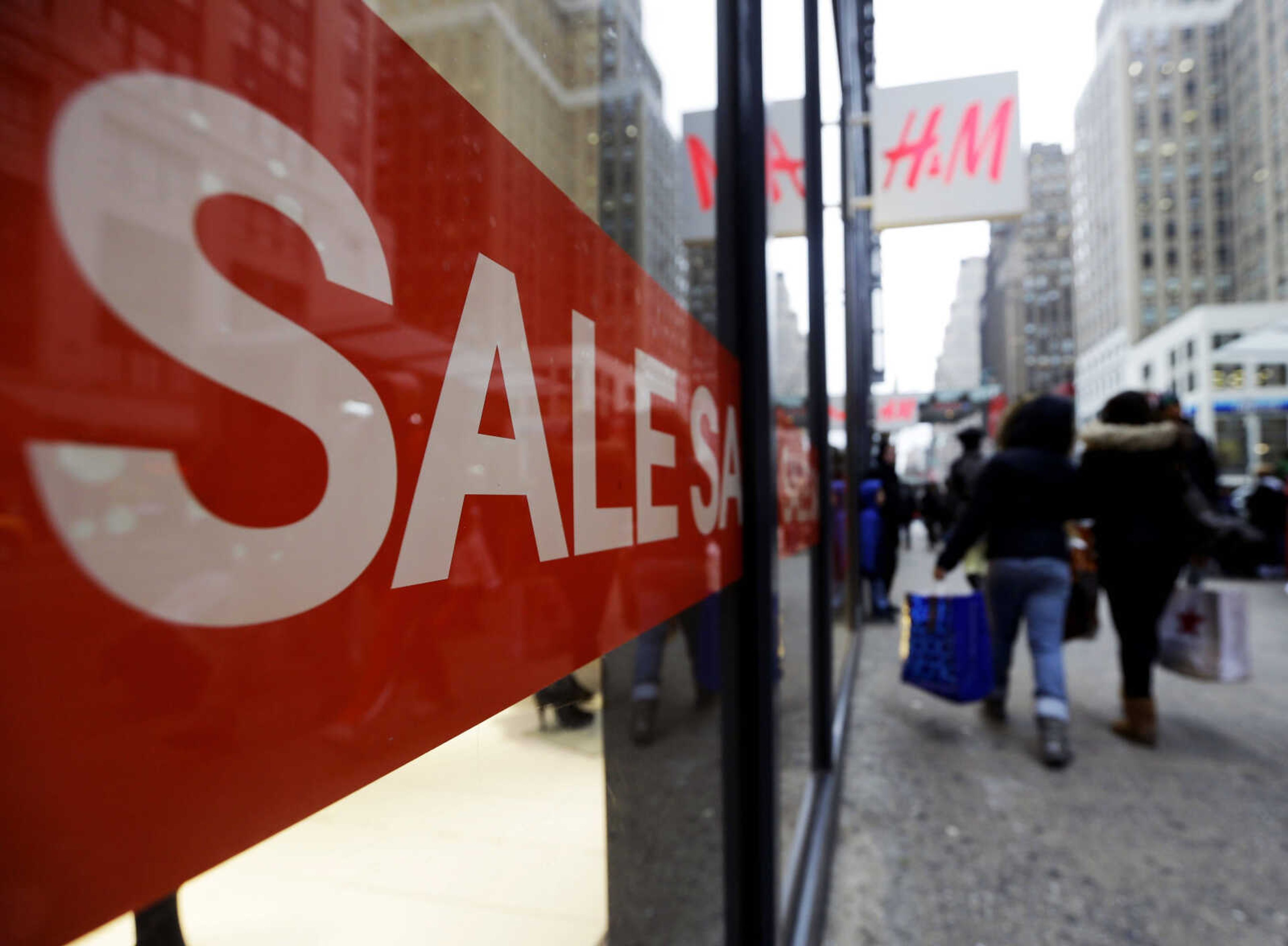 Shoppers walk past an H&M location, Wednesday, Dec. 26, 2012, in New York. This holiday season is shaping up to be the weakest since the country was in the middle of a deep recession in 2008. That not only shows that stores misread Americans' willingness to spend during this period of economic uncertainty. It also could indicate that the days of throngs of shoppers spending thousands of dollars willy nilly on holiday gifts may be long gone. (AP Photo/Frank Franklin II)