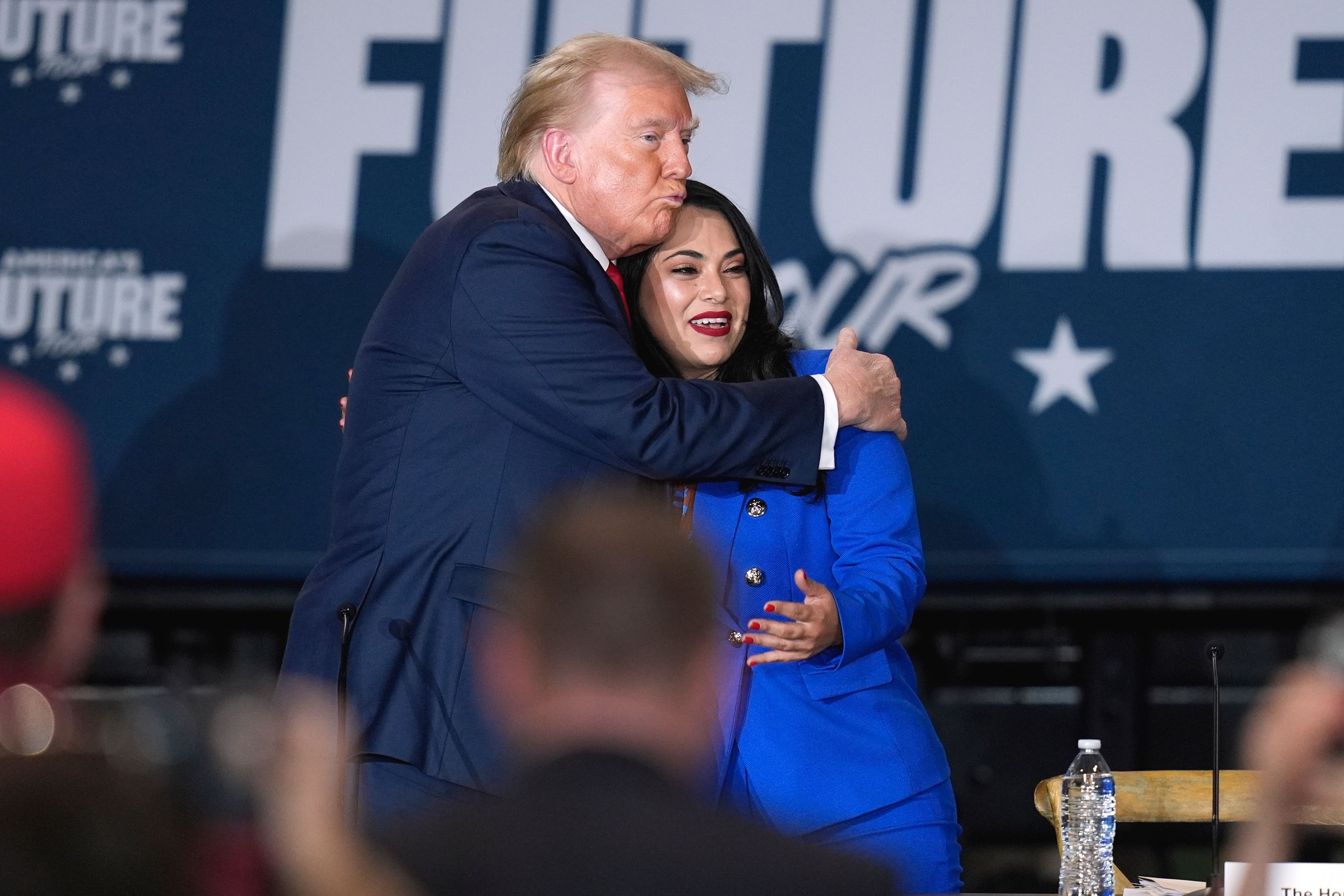 Republican presidential nominee former President Donald Trump, left, hugs Republican House candidate Mayra Flores at a campaign event at Beauty Society, Saturday, Oct. 12, 2024, in North Las Vegas, Nev. (AP Photo/John Locher)