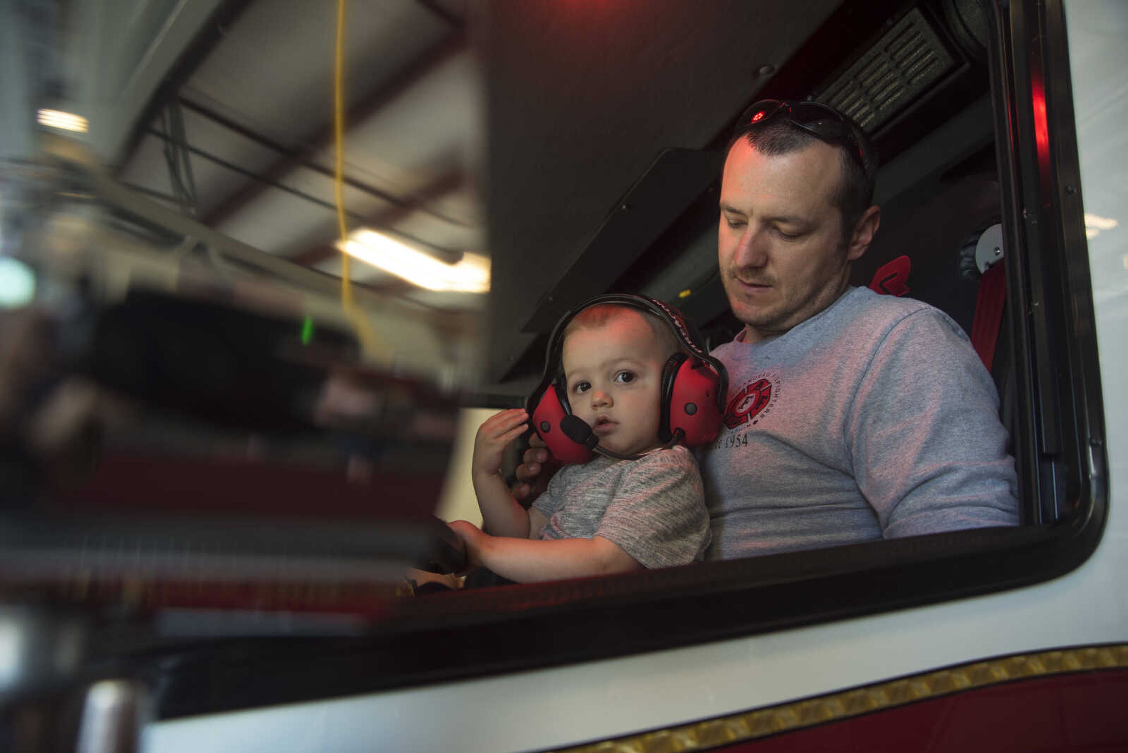 Nick Lucky and his son Asher Lucky sit in the front seat of a fire truck during the showing of the six Cape Girardeau fire trucks purchased at fire station number two Saturday, April 15, 2017 in Cape Girardeau. The National Fire Protection Association recommends fire departments to rotate their fleet every 10 years costing approximately $3.8 million dollars.