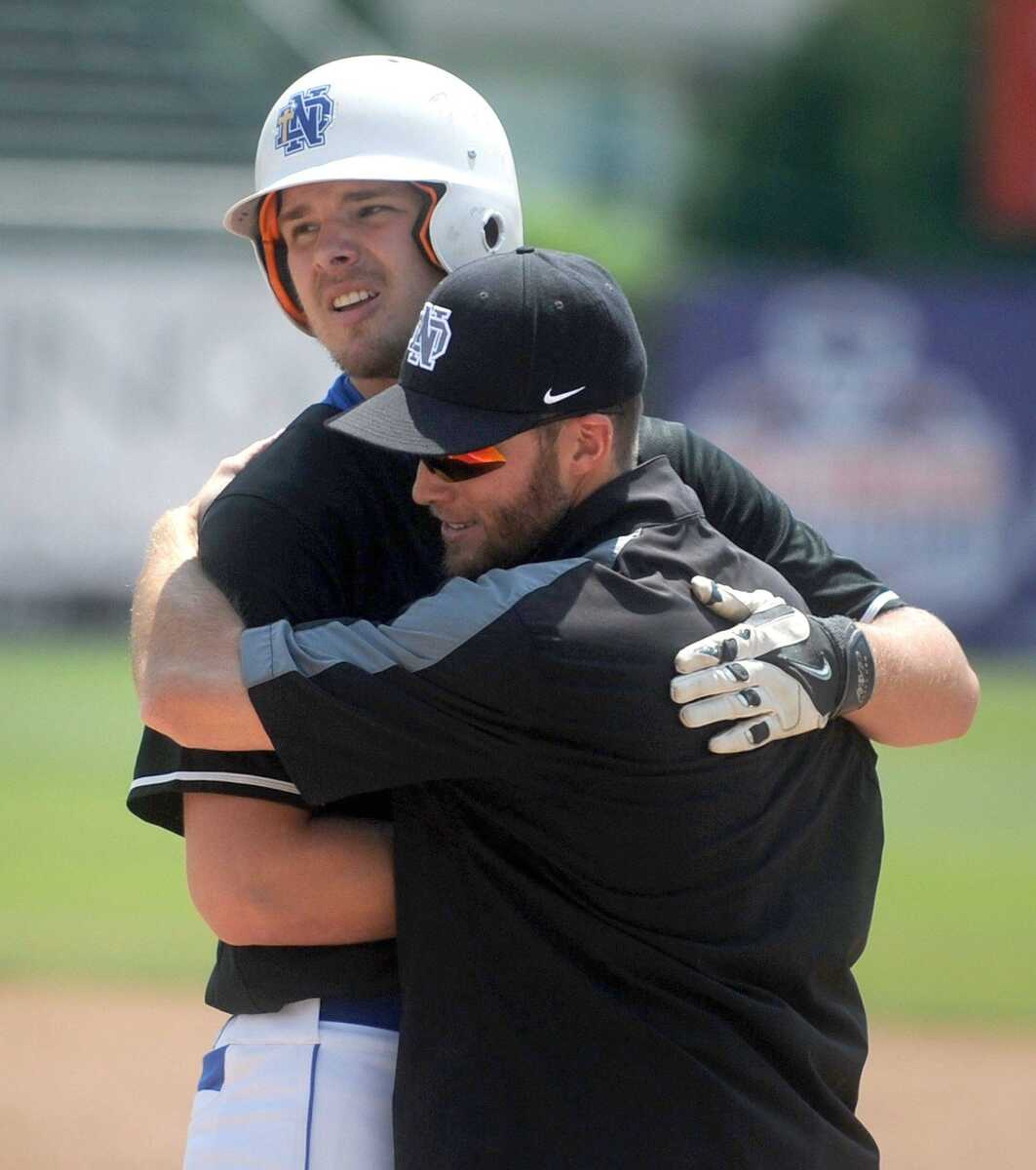 Notre Dame's Derek Hulshof is embraced by the first base coach after hitting an RBI single in the fourth inning of the Class 4 championship game against Sullivan, Saturday, June 6, 2015, in O Fallon, Missouri. Notre Dame won 17-0 in five innings. (Laura Simon)